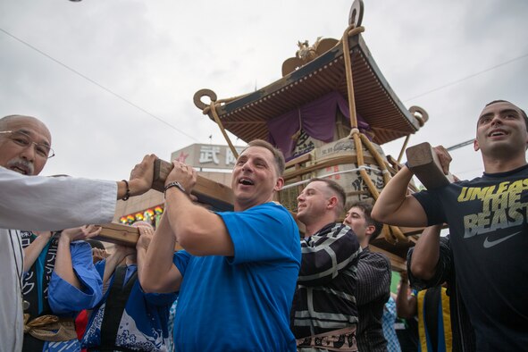 Col. Scott Maskery, 374th Mission Support Group commander, carries a mikoshi shrine with airmen in front of Fussa City Hall, Fussa city, Japan, Aug. 8, 2014. Multiple shrines were carried from the Fussa shinmei-sha, shinto shrine, to City Hall during the 64th annual Fussa Tanabata Festival. (U.S. Air Force photo by Osakabe Yasuo/Released)