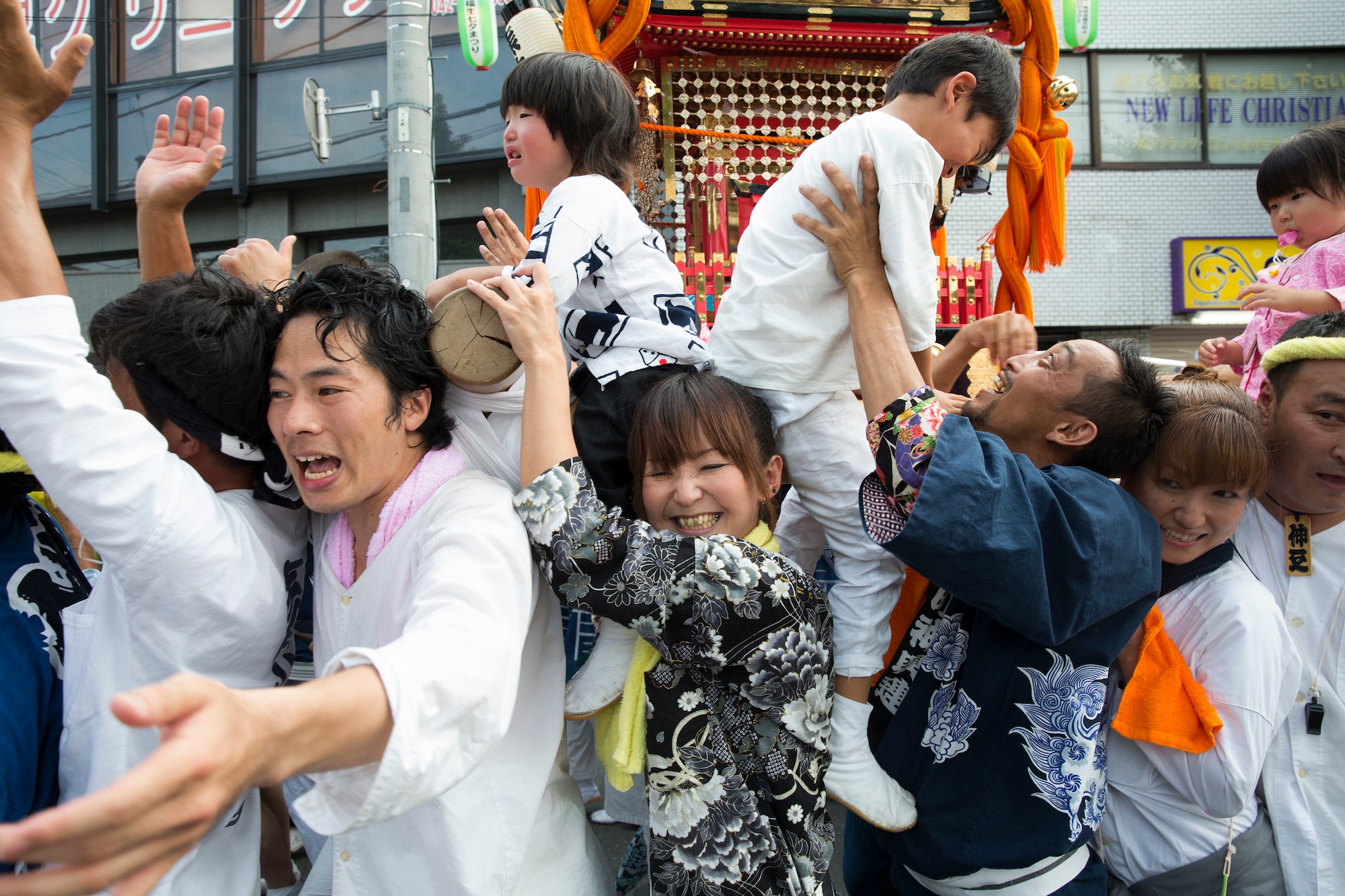 Mikoshi shrine carriers hoist their shrine with their kids at Fussa city, Japan,  Aug. 8, 2014. Multiple shrines were carried from the Fussa shinmei-sha, shinto shrine, to City Hall during the 64th annual Fussa Tanabata Festival. (U.S. Air Force photo by Osakabe Yasuo/Released)