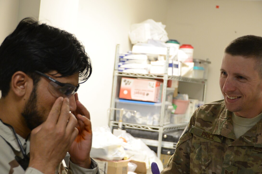 U.S. Air Force Staff Sgt. Vernon Price, a medical technician assigned to the 455th Expeditionary Medical Group, smiles after watching an Afghan soldier adjust to his new prosthetic eye, while at the Craig Joint Theater Hospital at Bagram Airfield, Afghanistan Aug. 7, 2014. The soldier suffered an eye trauma when shrapnel from an explosion hit him four months ago. Price is a native of Goldsborough, N.C. and deployed form the 4th Aerospace Medicine Squadron at Seymour Johnson Air Force Base, N.C. (U.S. Air Force photo by Master Sgt. Cohen A. Young/Released)