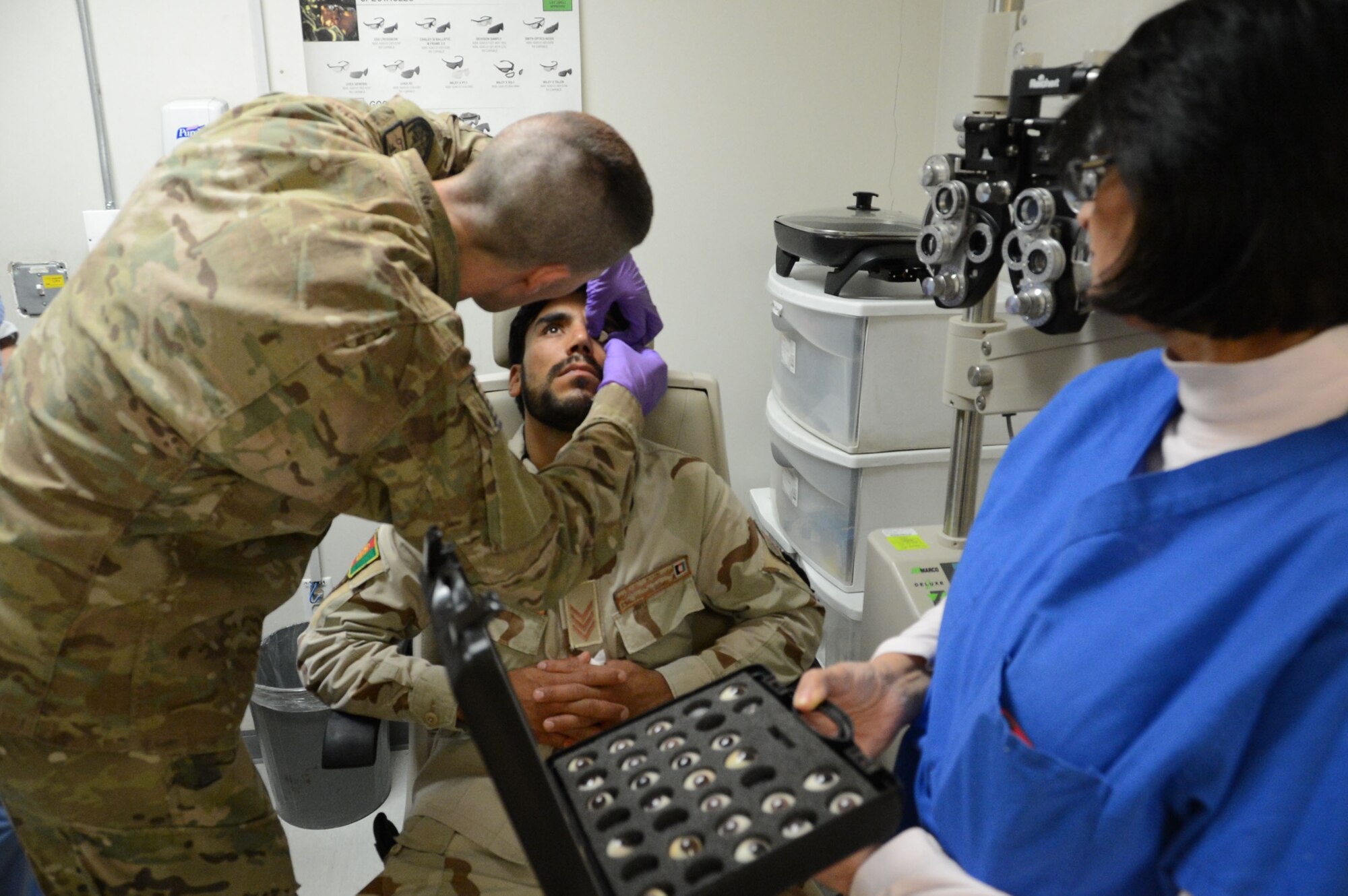 U.S. Air Force Staff Sgt. Vernon Price, a medical technician assigned to the 455th Expeditionary Medical Group, places a prosthetic eye into the left eye socket of an Afghan soldier while at the Craig Joint Theater Hospital at Bagram Airfield, Afghanistan Aug. 7, 2014. The soldier suffered an eye trauma when shrapnel from an explosion hit him four months ago. Price is a native of Goldsborough, N.C. and deployed form the 4th Aerospace Medicine Squadron at Seymour Johnson Air Force Base, N.C. (U.S. Air Force photo by Master Sgt. Cohen A. Young/Released)