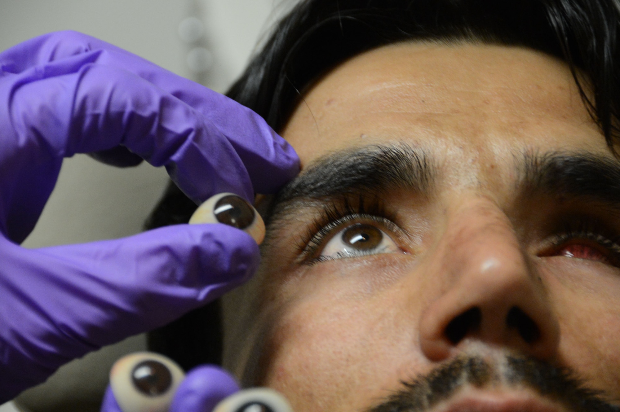 U.S. Air Force Staff Sergeant Vernon Price, a medical technician assigned to the 455th Expeditionary Medical Group, compares the likeness of an assortment of prosthetic left-eyeballs to an Afghan soldier’s right eye prior to placing the prosthetic into his empty eye socket while at the Craig Joint Theater Hospital at Bagram Airfield, Afghanistan Aug. 7, 2014. The soldier suffered an eye trauma when shrapnel from an explosion hit him four months ago. Price is a native of Goldsborough, N.C. and deployed form the 4th Aerospace Medicine Squadron at Seymour Johnson Air Force Base, N.C. (U.S. Air Force photo by Master Sgt. Cohen A. Young/Released)