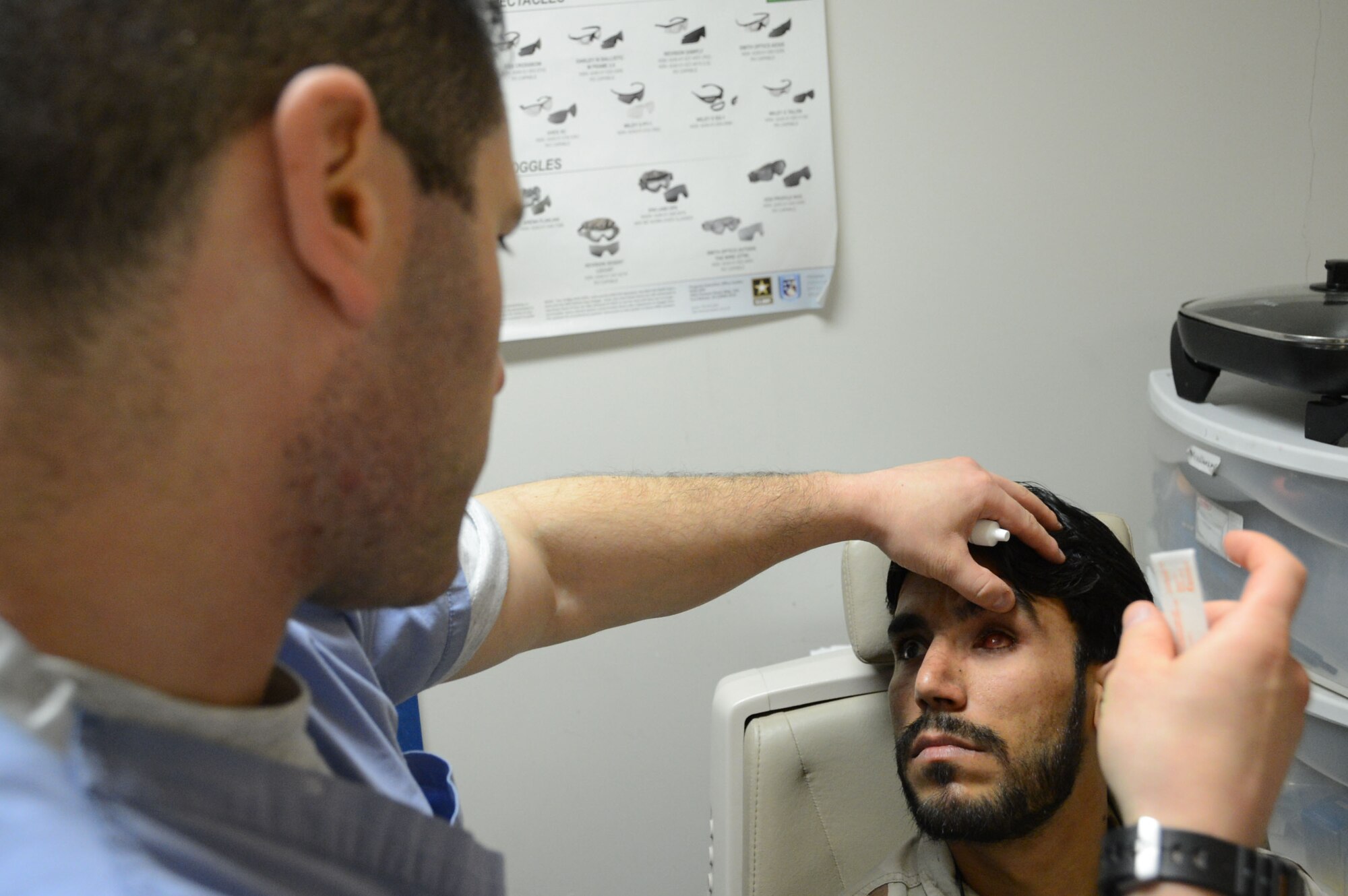 U.S. Air Force Maj. Michael Parsons, an ophthalmologist assigned to the 455th Expeditionary Medical Group, checks the eye muscles of the left eye socket of an Afghan soldier prior to placing a prosthetic into his empty eye socket while at the Craig Joint Theater Hospital at Bagram Airfield, Afghanistan Aug. 7, 2014. The soldier suffered an eye trauma when shrapnel from an explosion hit him four months ago. Parsons is a native of Poughkeepsie, N.Y. and deployed form the 88th surgical squadron at Wright-Patterson Air Force Base, Ohio. (U.S. Air Force photo by Master Sgt. Cohen A. Young/Released)