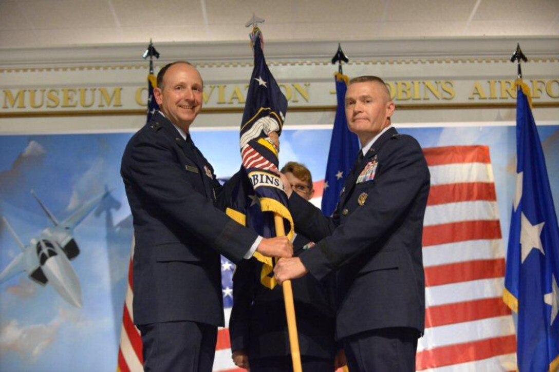 Lt. Gen. Bruce Litchfield, Air Force Sustainment Center commander (left), passes the guidon to Brig. Gen. Walter Lindsley during the Warner Robins Air Logistics Complex change of command ceremony at the Museum of Aviation Aug. 11. Lindsley was formerly the Air Force Materiel Command director of staff. Brig. Gen. Cedric George, the former complex commander, is leaving Robins to take a position at Air Force headquarters as director of system integration in the Office of the Deputy Chief of Staff
for Logistics, Installations and Mission Support. (U.S. Air Force photo by Ray Crayton)
