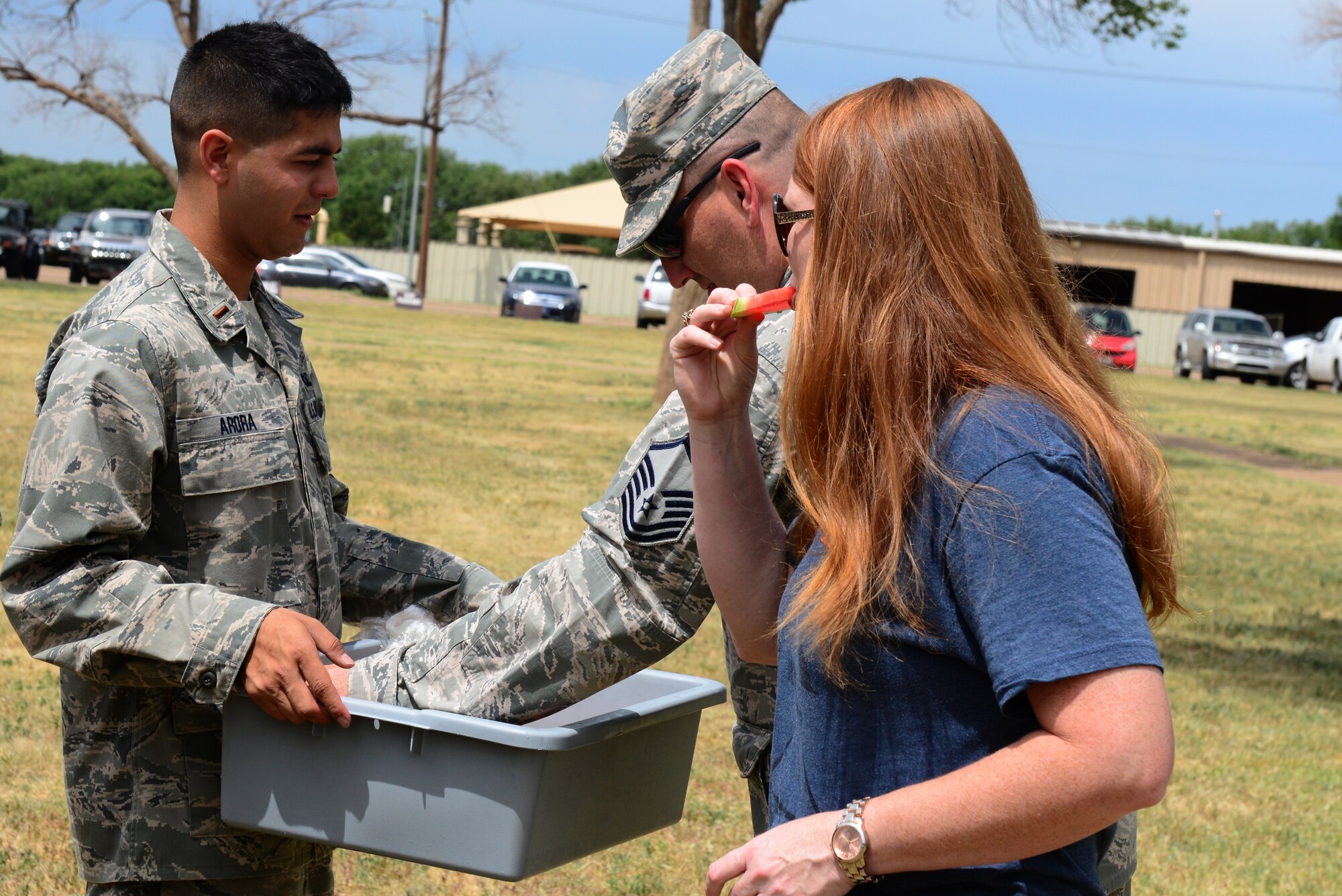 U.S. Air Force 2nd Lt. Joseph Arora, 27th Special Operations Support Squadron airfield operations officer,  offers watermelon to Air Commandos lined up for hot dogs and hamburgers at Cannon Appreciation Day, Aug. 8, 2014 at Cannon Air Force Base, N.M. Volunteers served hundreds of Air Commandos who came out to celebrate the base’s connection to the surrounding community. (U.S. Air Force Photo/Airman 1st Class Shelby Kay-Fantozzi) 