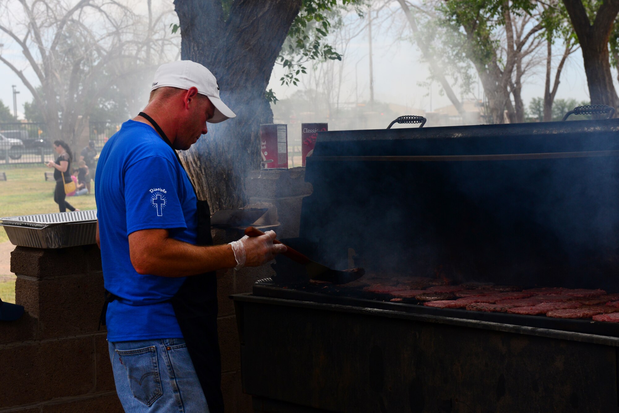 A volunteer from Clovis, N.M., prepares hot dogs and hamburgers for Air Commandos at Cannon Appreciation Day, Aug. 8, 2014 at Cannon Air Force Base, N.M. Volunteers served hundreds of Air Commandos who came out to celebrate the base’s connection to the surrounding community. (U.S. Air Force Photo/Airman 1st Class Shelby Kay-Fantozzi)