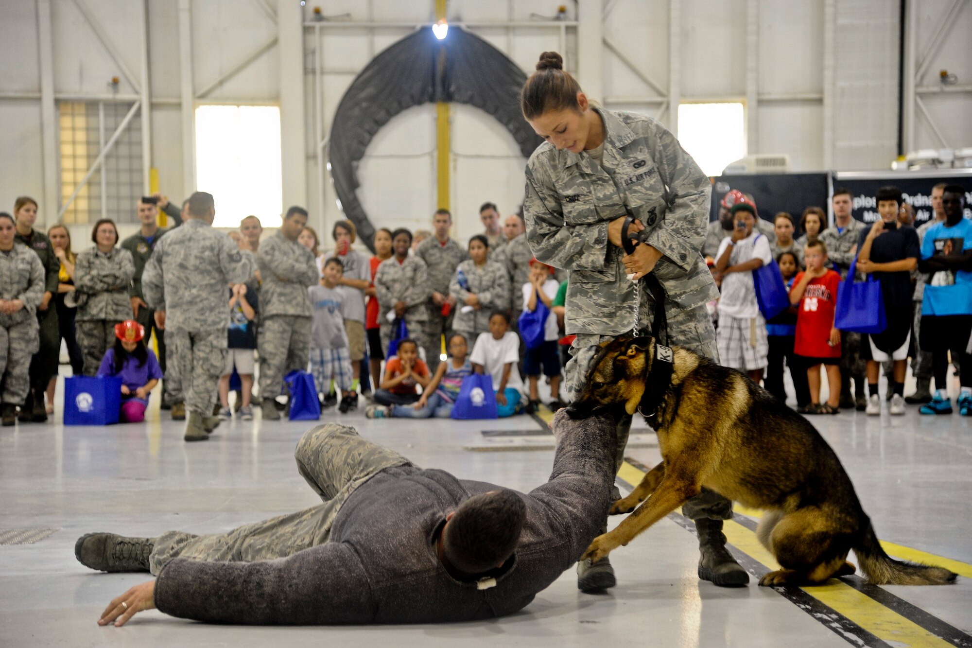 Staff Sgt. Jessica Cruz, 22nd Security Forces Squadron military working dog handler, performs a K-9 demonstration for children from the Sedgwick County chapter of Big Brothers Big Sisters program, Aug. 8, 2014, at McConnell Air Force Base, Kan. McConnell has partnered with the Big Brothers Big Sisters for more than 25 years. (U.S. Air Force photo/Airman 1st Class John Linzmeier)