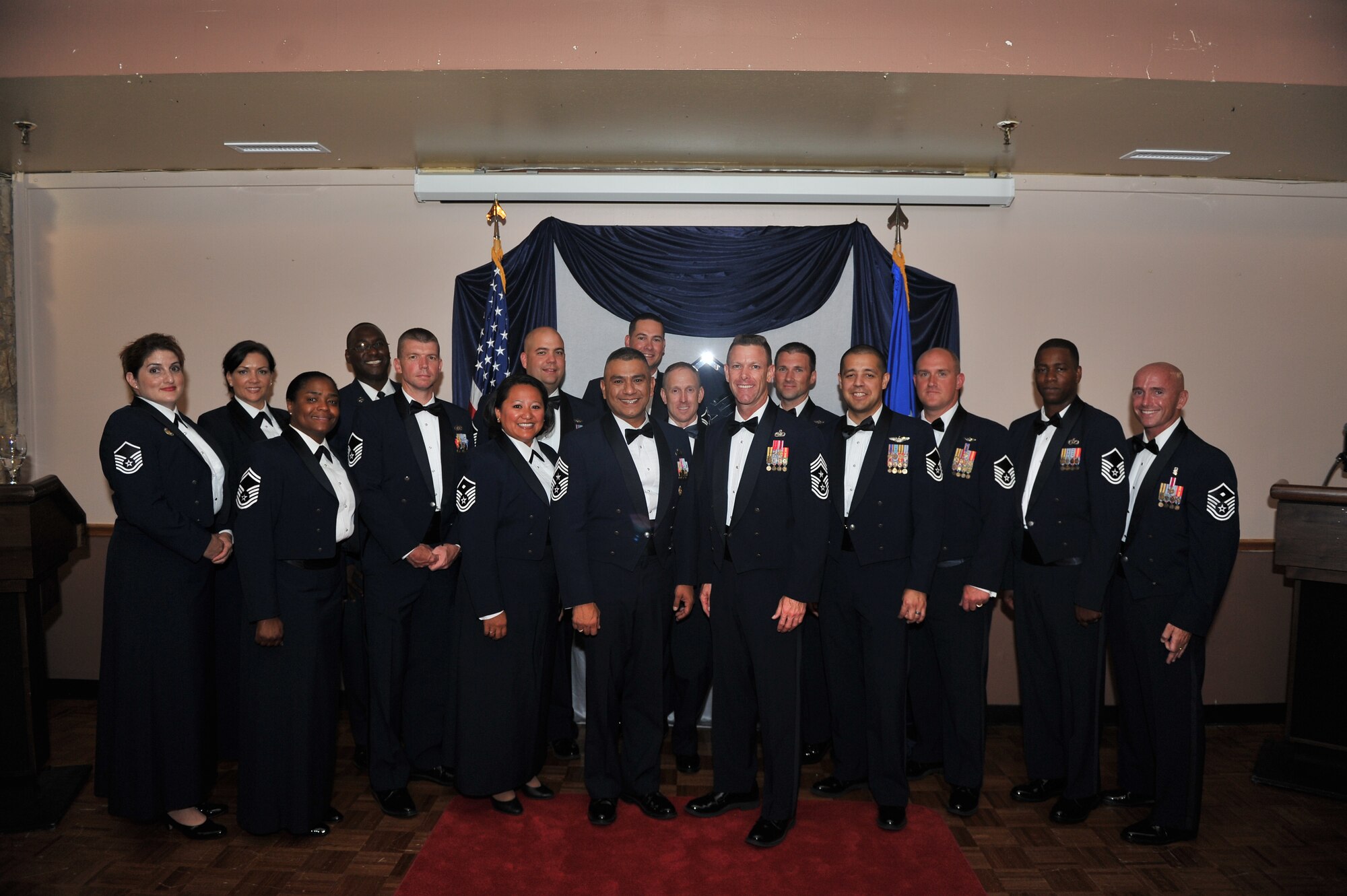 ALTUS AIR FORCE BASE, Okla. – Members of the Senior NCO Induction Ceremony Committee pose for a group photo with U.S. Air Force Chief Master Sgt. Gerardo Tapia, command chief of Air Education and Training Command, and U.S. Air Force Chief Master Sgt. Bryan Creager, 97th Air Mobility Wing command chief, after the Senior NCO Induction Ceremony inside Club Altus Aug. 8, 2014. The ceremony recognized the inductees’ rite of passage into the top enlisted tier of the Air Force and allowed friends and family members to join in congratulating the honored members. (U.S. Air Force photo by Senior Airman Dillon Davis/Released)