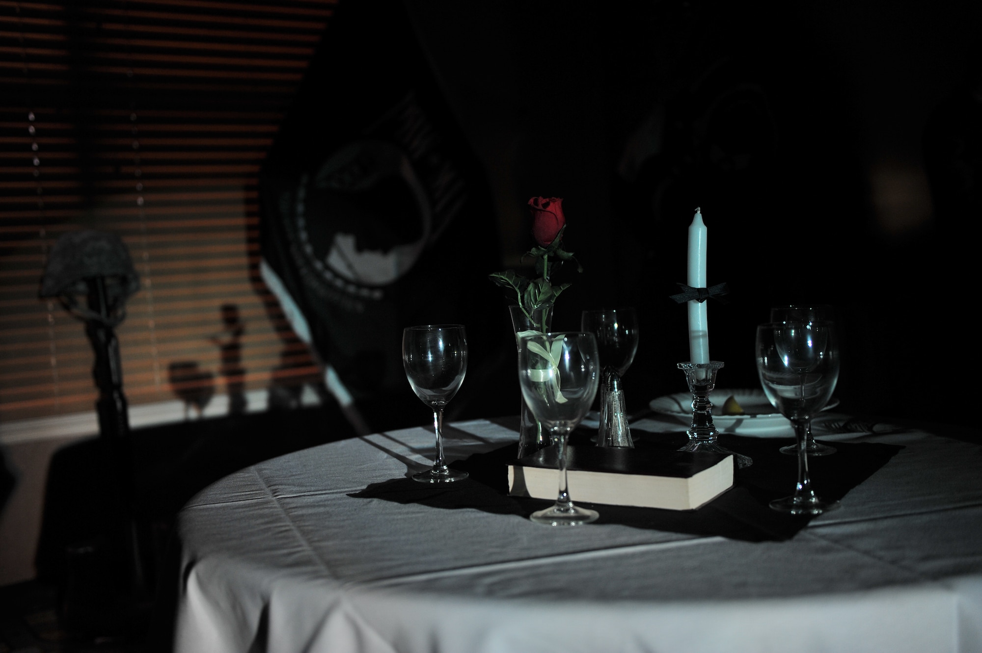 ALTUS AIR FORCE BASE, Okla. – Table settings for POW/MIA military members rest at an empty table during the Senior NCO Induction Ceremony Aug. 8, 2014. The POW/MIA remembrance table is a traditional part of many ceremonies and pays respects to those who are prisoners of war or missing in action. (U.S. Air Force photo by Senior Airman Dillon Davis/Released)