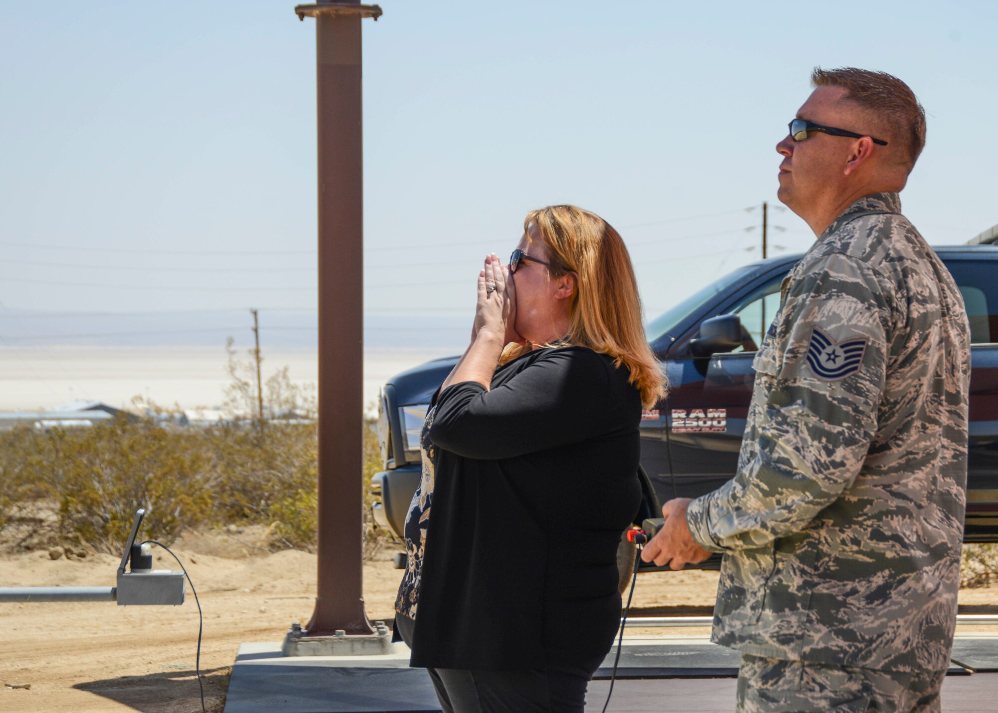 Elizabeth Doss, 412th Test Wing Public Affairs director, shouts “fire in the hole” three times before igniting 1.25 pounds of C-4 at the Explosive Ordinance Disposal compound Aug. 8. Doss attended a tour of 412th Civil Engineering Directorate facilities designed to familiarize new commanders with the CE mission. (U.S. Air Force photo by Rebecca Amber)
