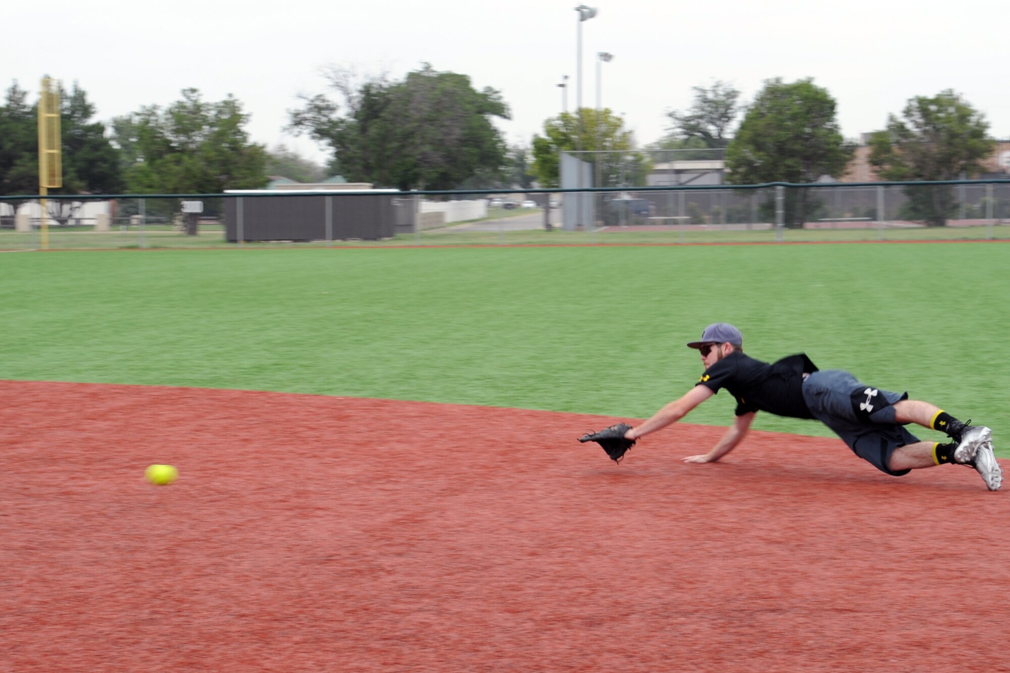 GOODFELLOW AIR FORCE BASE, Texas -- Nicholas O’Keefe, 17th Civil Engineer Squadron Bandits player, slides to catch a ball during a photo shoot at the Mathis Fitness Center multipurpose field June 30. O’Keefe has been playing for 12 years since he was 7 years old and has participated in football, basketball and track. (U.S. Air Force photo/ Staff Sgt. Laura R. McFarlane)