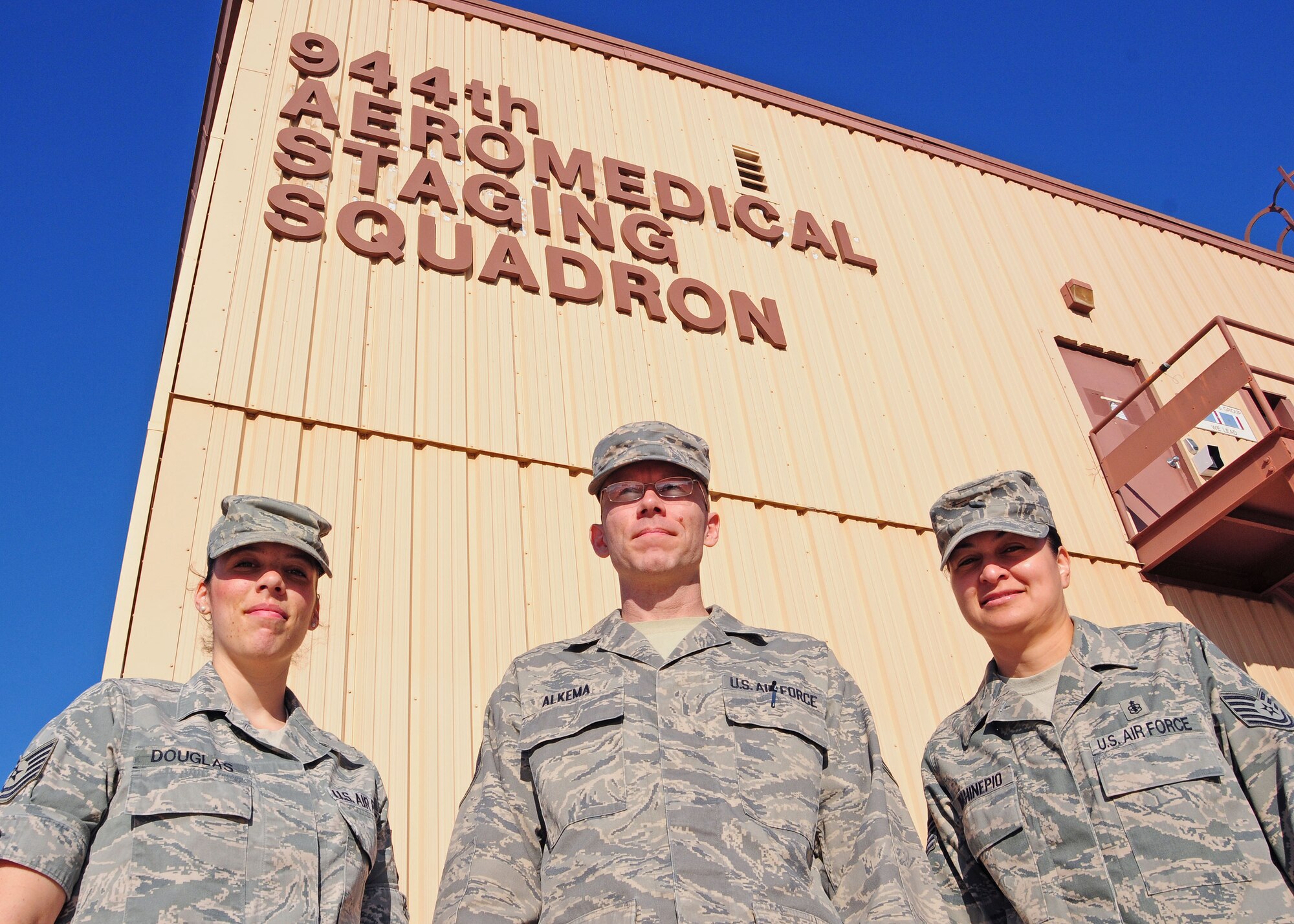 Tech. Sgt. Sara Douglas,, Tech. Sgt. Gregory Alkema, and Tech. Sgt. Mayline Wahinepio 944th Aeromedical Staging Squadron mental health technicians, pose for a photo in front of their building August 8 prior to the unit training assembly at Luke Air Force base, Ariz.