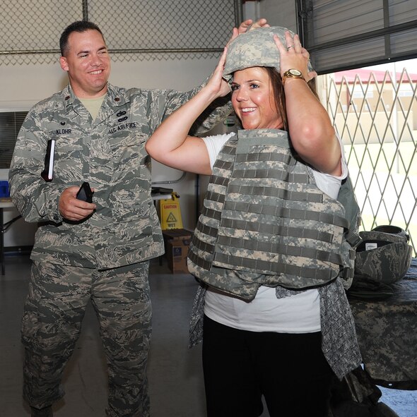 Ashley Ewbank , the 71st Communication Squadron honorary commander, tries on a flak vest and helmet with the help of Maj. John Klohr, the 71st Logistics Readiness Squadron commander, Aug 7 in Building 288 during the Mission Support Group tour.  The purpose of Team Vance's Honorary Commander Program is to bring community leaders of varying backgrounds and interests together in partnership with base units. During their tenure, honorary commanders visit each of the three groups at Vance and attend various events with their respective squadron commanders.  (U.S. Air Force photo/Staff Sgt. Nancy Falcon)