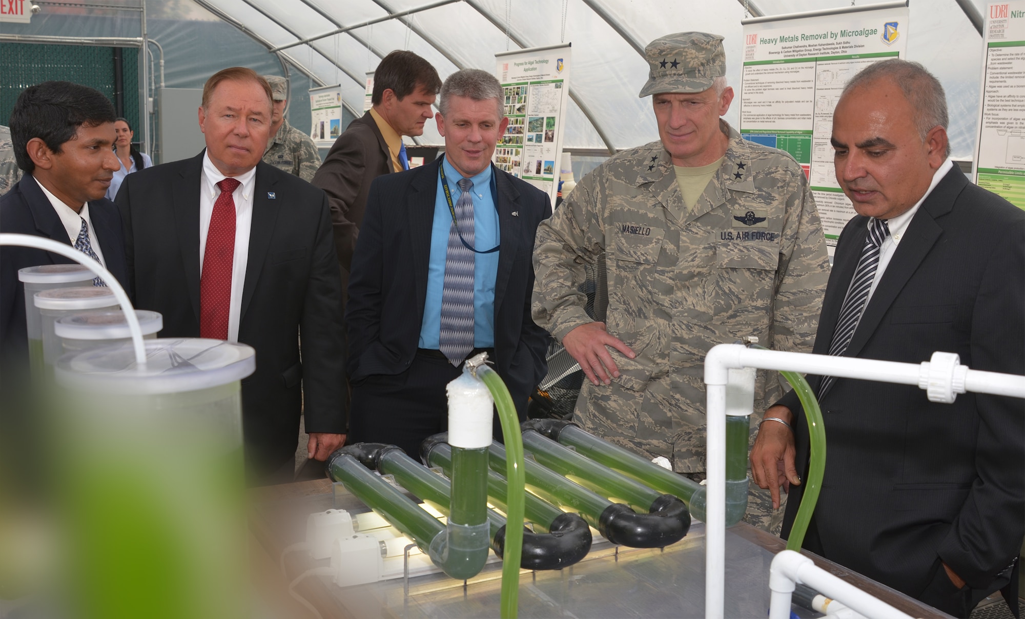 Dr. Sukh Sidhu (right) briefs Maj. Gen. Tom Masiello during a tour of the Outdoor Algae Research Facility August 6 at the University of Dayton Research Institute. The Air Force Research Laboratory is teaming with UDRI on using algae both as an alternative biofuel source and to capture carbon dioxide to reduce impacts of global warming. Also pictured from left are Dr. Moshan Kahandawala, UDRI group lead for Bioenergy and Carbon mitigation, Dr. Mickey McCabe, vice president for UD Research, and Mr. Tom Lockhart, director of AFRL's Materials and Manufacturing directorate. Dr. Sidhu is UDRI Energy Technologies and Materials division lead and Maj. Gen. Masiello, the AFRL commander. (U.S. Air Force edited photo/Mikee Huber)