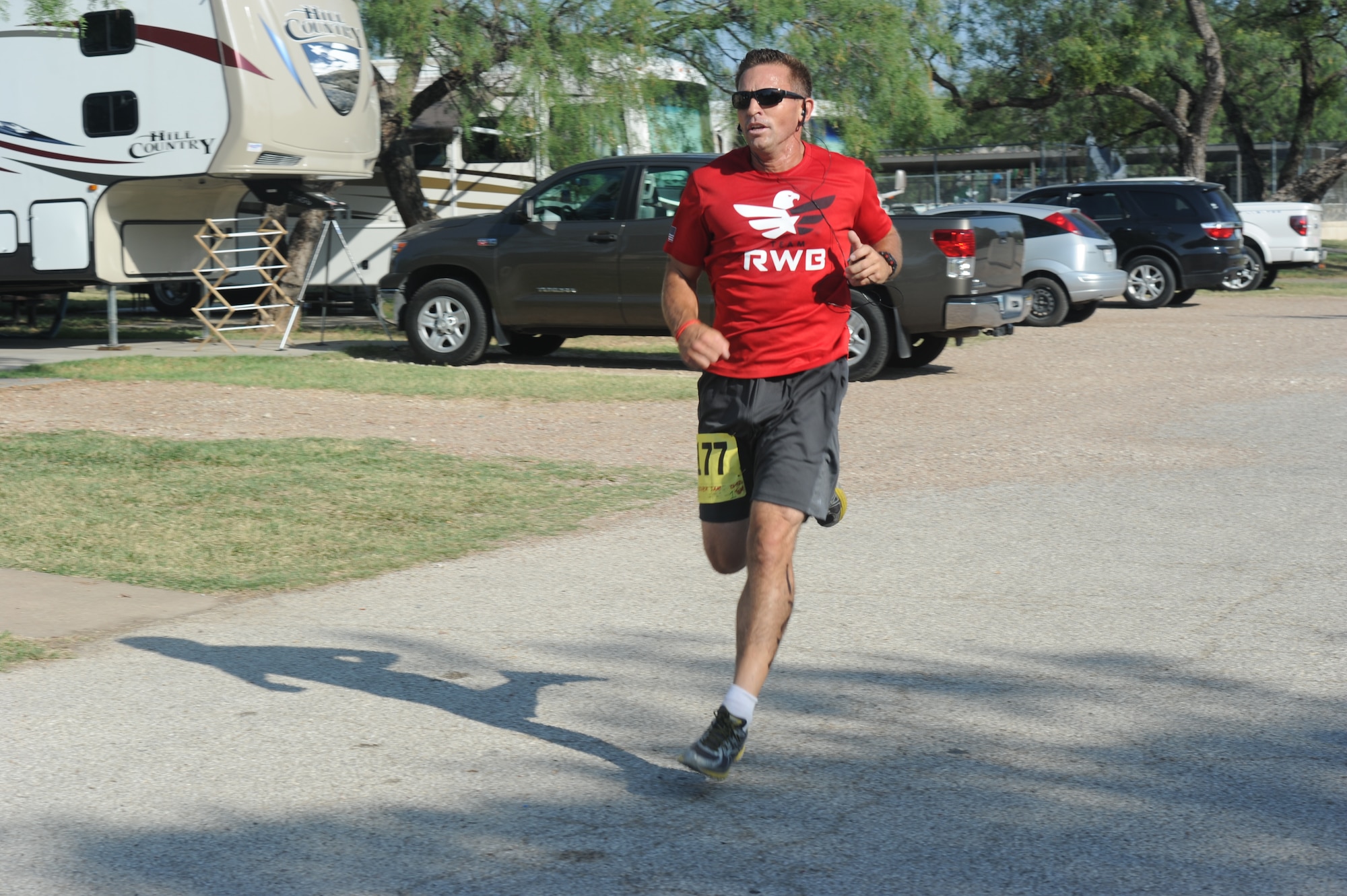 GOODFELLOW AIR FORCE BASE, Texas -- Samuel L. Spooner III, 17th Training Wing safety chief, runs the last leg of the race during the 2014 Annual Triathlon at the Goodfellow Recreation Camp July 26. Spooner ran as part of a co-ed team that completed the competition with an overall time of 1:13:30. (U.S. Air Force photo/ Staff Sgt. Laura R. McFarlane)