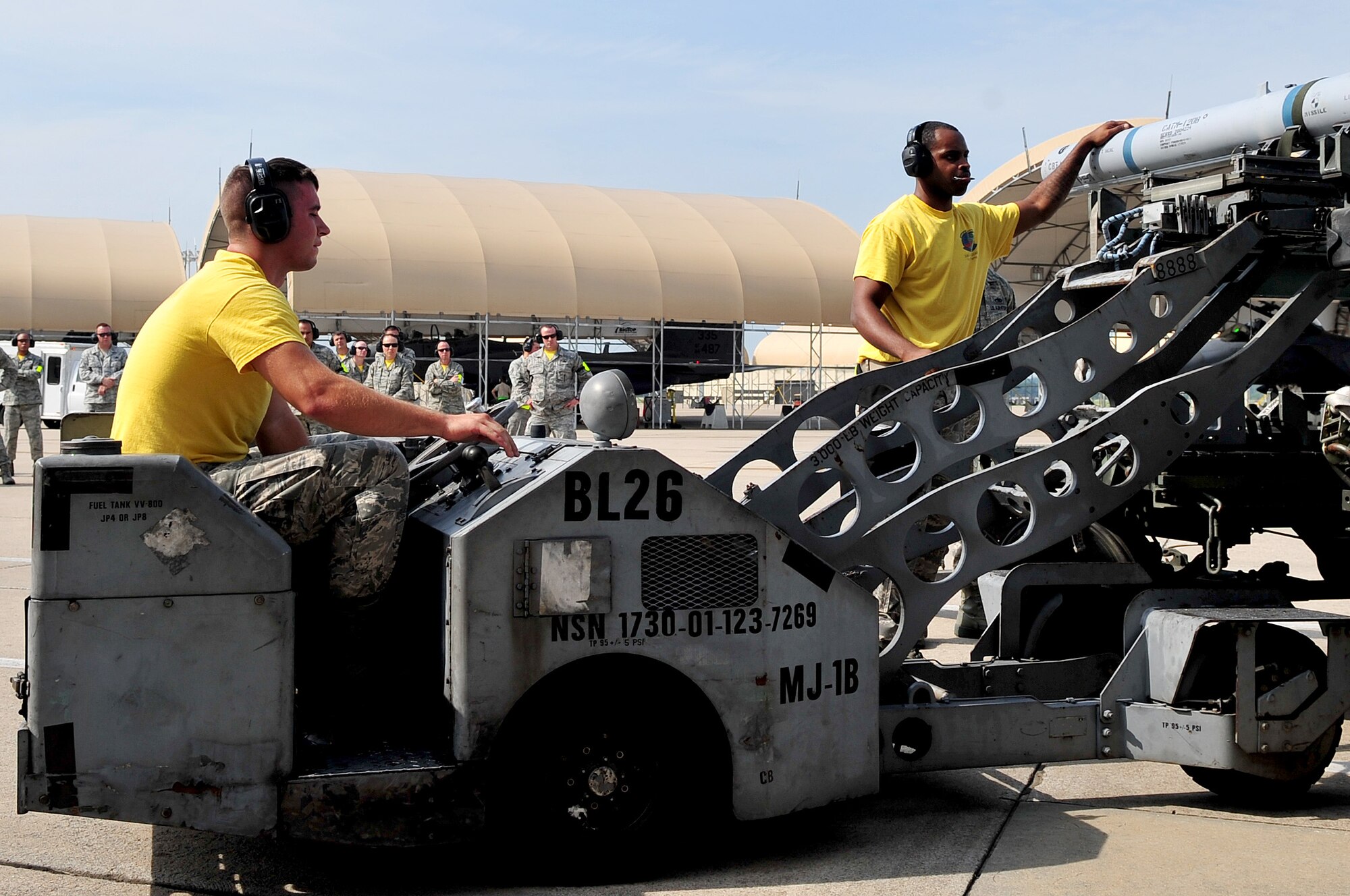 Senior Airman Aaron Miller (left), and Staff Sgt. Jacoby McLaurin, 336th Aircraft Maintanence Unit weapons loadcrew memberstransport a jammer to an F-15E Strike Eagle, Aug. 8, 2014, during a loadcrew competition at Seymour Johnson Air Force Base, North Carolina. The quarterly competition showcases a three-man crew from each aircraft maintanence unit. (U.S. Air Force photo/Airman 1st Class Shawna L. Keyes)