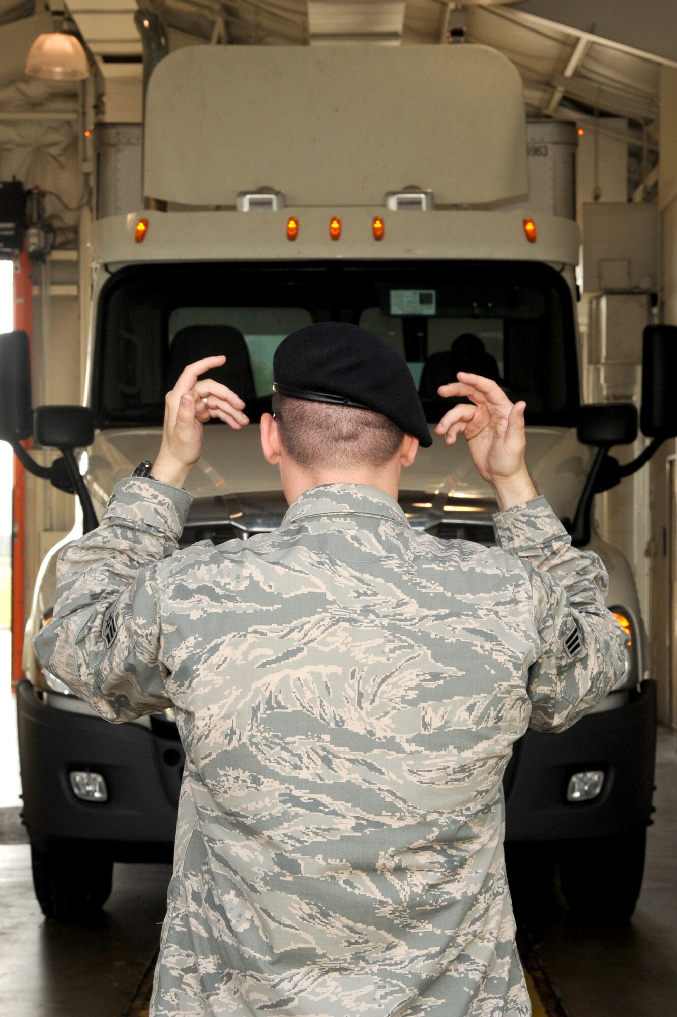Senior Airman Benjamin Turley, 375 Security Forces installation entry controller, guides a truck into the Commercial Vehicle Inspection Station Aug. 6, 2014 at Scott Air Force Base, Ill. Members at the CVIS can inspect up to roughly 3,000 vehicles a month, making sure contraband or any illegal substance stays off the installation. (U.S. Air Force photo/ Senior Airman Tristin English)