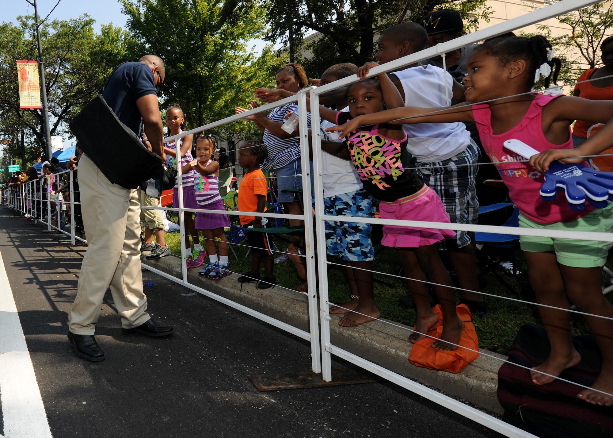 Master Sgt. Sherwin Severin, United States Air Force Pallbearer Flight Superintendent hands out USAF memorabilia during the Bud Billiken Parade in Chicago, Il., August 9, 2014. The 40-person formation marched in front of a live and televised audience of millions of people. (U.S. Air Force photo/ Senior Airman Nesha Humes)