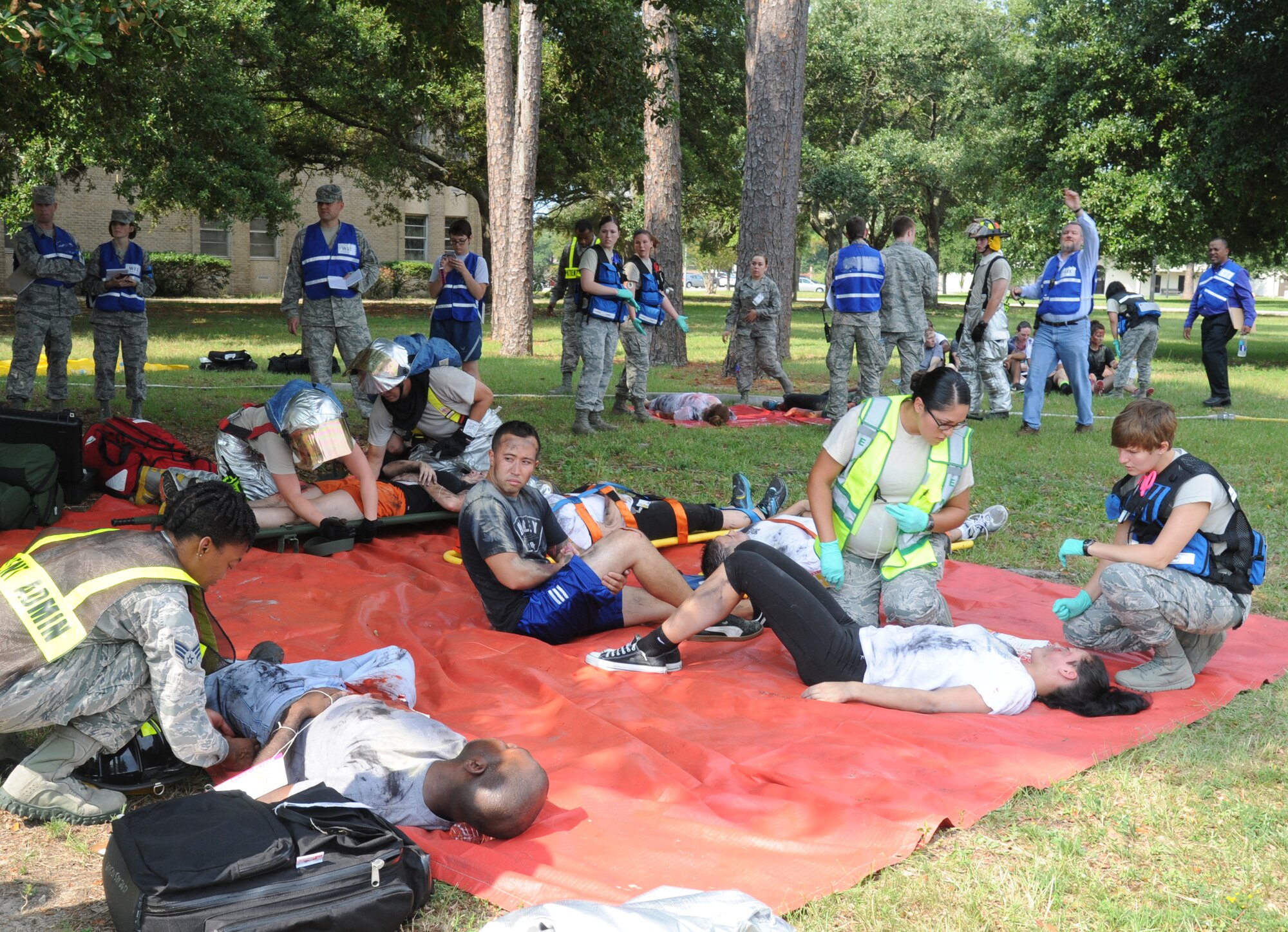 Members from the Keesler fire department and the 81st Medical Group provide medical attention to “victims” during a major accident response exercise Aug. 7, 2014, at the Locker House at Keesler Air Force Base, Miss. Team Keesler practiced real-world training during the exercise which simulated a gas line explosion that set a building on fire. Due to the extreme temperatures, exercise “players” wore minimal fire gear.  (U.S. Air Force photo by Kemberly Groue)