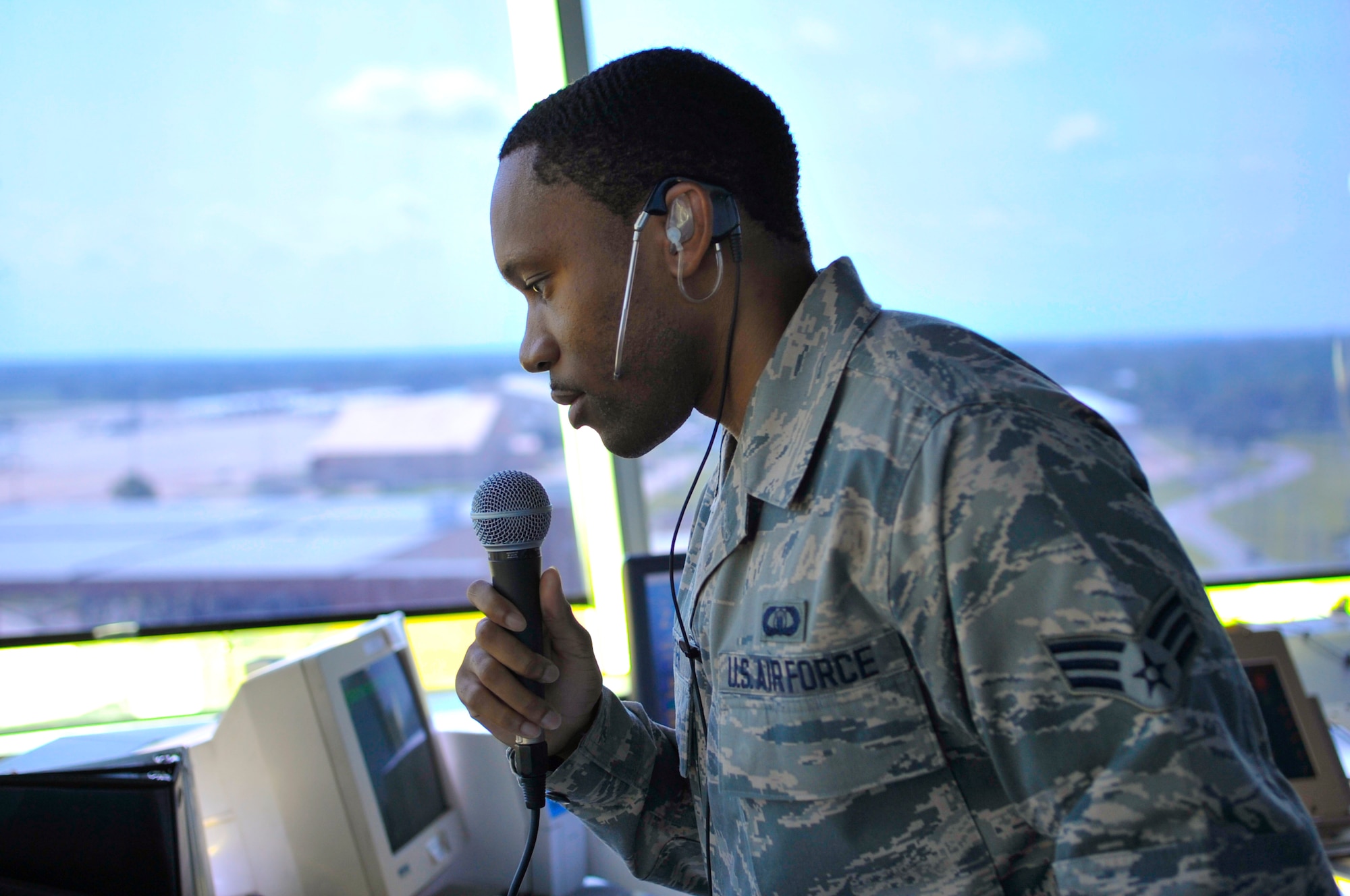 Senior Airman John Porter, air traffic control operator,  uses a microphone to communicate with pilots on Barksdale Air Force Base, La., Aug. 8, 2014. The microphone sends a voice recording to a computer program that pilots can dial into to receive additional information on flight conditions, such as weather, potential hazards, and a flock of birds. (U.S. Air Force photo/Airman 1st Class Benjamin Raughton)