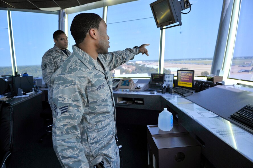 Senior Airman John Porter, 2nd Operations Support Squadron air traffic control tower operator, points to a vehicle driving on the runway on Barksdale Air Force Base, La,. Aug. 8, 2014. Porter communicated with the vehicle driver to ensure the runway ahead was safe for the vehicle to continue crossing. (U.S. Air Force photo/Airman 1st Class Benjamin Raughton)