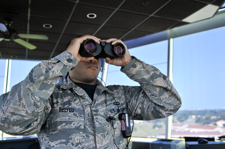 Staff Sgt. Colin Belyeu, 2nd Operations Support Squadron air traffic control tower operator, looks at the runway through binoculars on Barksdale Air Force Base, La., Aug. 8, 2014. Air traffic control operators use a variety of other tools such as a light gun, computers and a microphone to communicate critical information to pilots. (U.S. Air Force photo/Airman 1st Class Benjamin Raughton)
