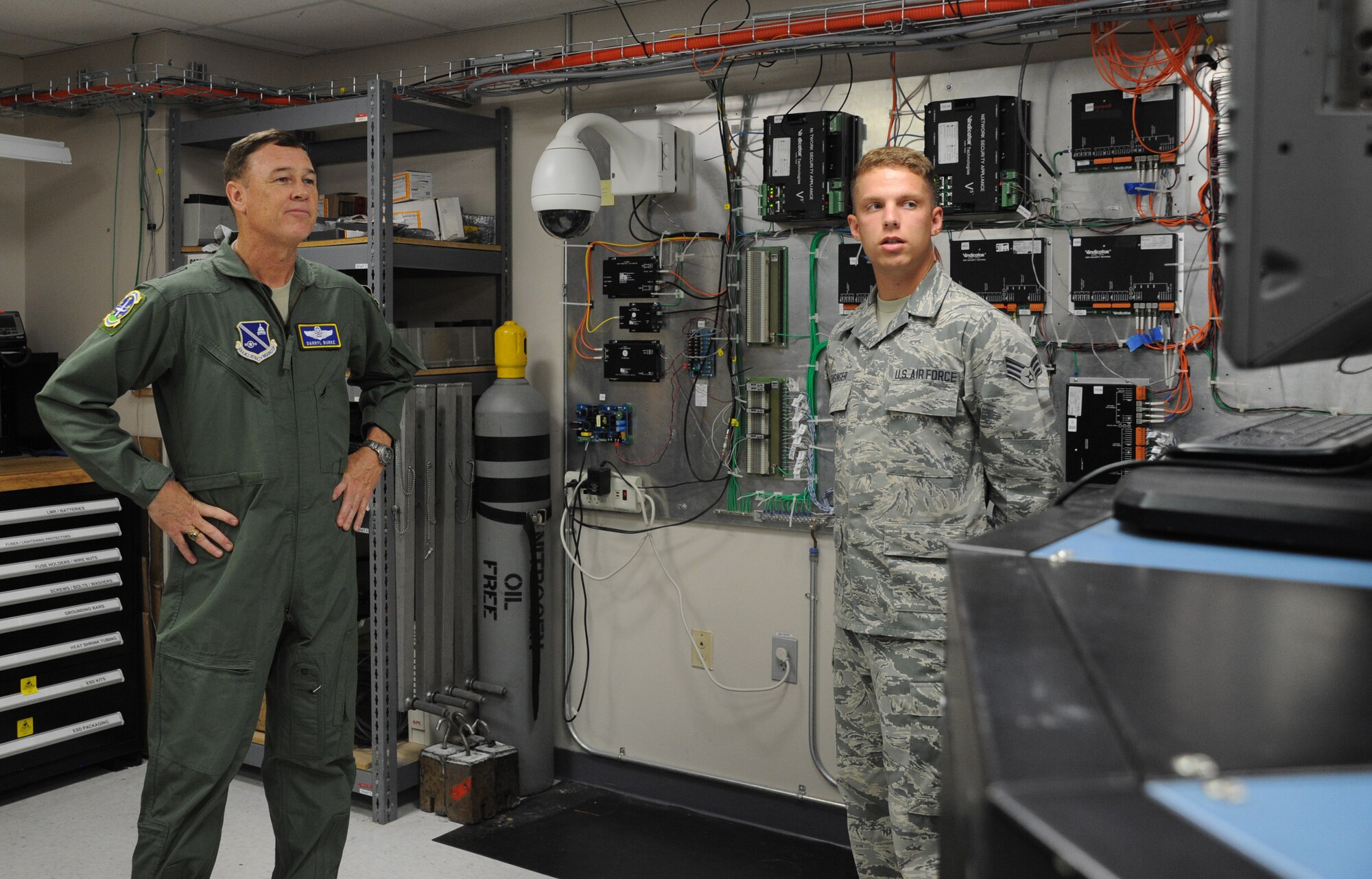 Senior Airman Zachary Hensigner briefs the visual imagery and intrusion detection systems shop’s mission to the Air Force District of Washington Commander Maj. Gen. Darryl Burke during the general’s visit to the 844th Communications Group at Joint Base Andrews, Maryland, Aug. 8, 2014. Airmen assigned to the visual imagery and intrusion detection systems shop support security systems for the presidential airlift group. Hensigner is a 744th Communications Squadron cyber transport technician. (U.S. Air Force photo/Master Sgt. Tammie Moore)