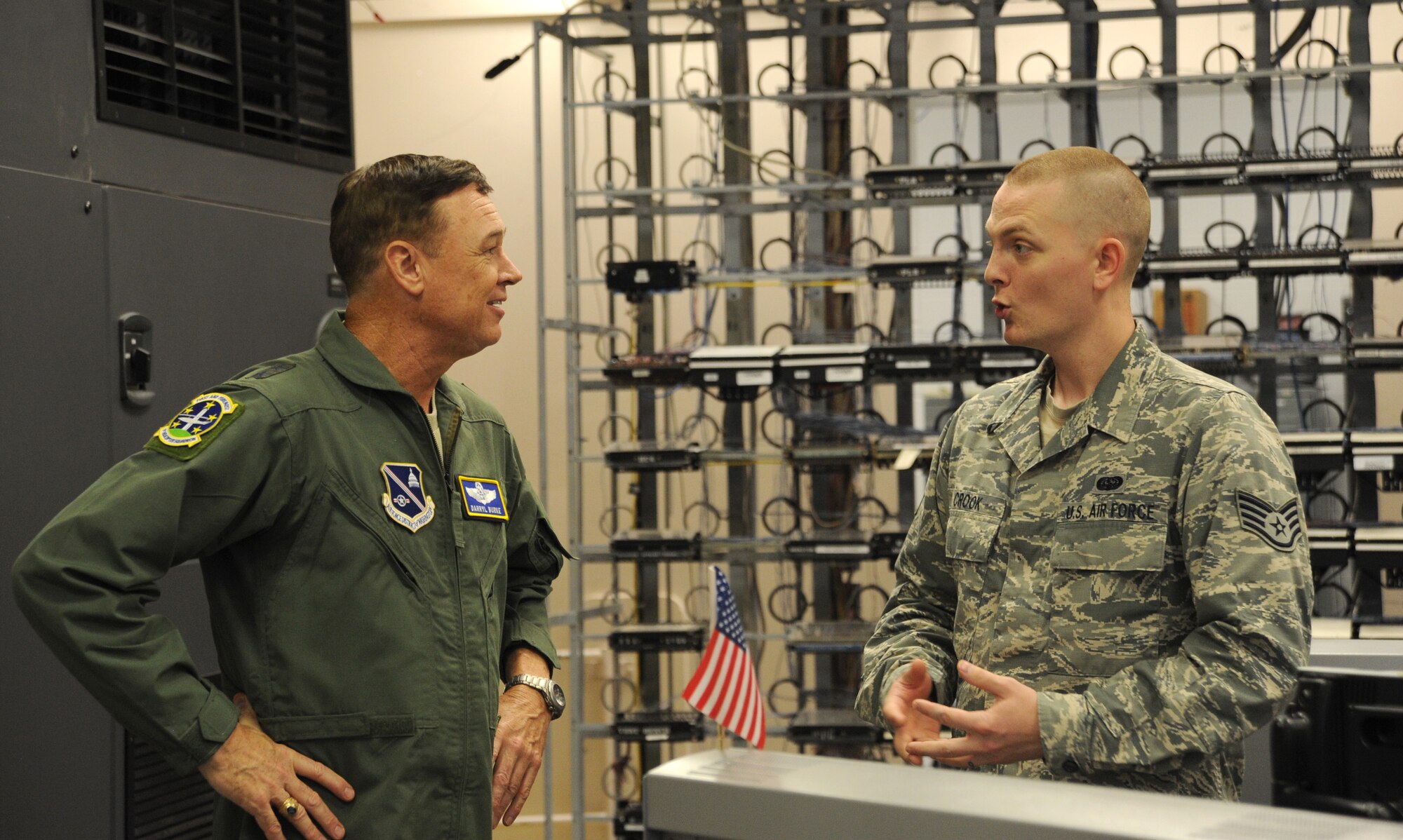 Staff Sgt. Kyle Crook explains the voice services shop mission to the Air Force District of Washington Commander Maj. Gen. Darryl Burke during the general’s visit to the 844th Communications Group at Joint Base Andrews, Maryland, Aug. 8, 2014. Airmen with the 844th CG establish and operate cyberspace equipment enabling customers to perform their mission on Joint Base Andrews, Joint Base Anacostia-Bolling and other sites throughout the National Capital Region. Crook is a 744th Communications Squadron Voice Services Shop cyber transport technician. (U.S. Air Force photo/Master Sgt. Tammie Moore)