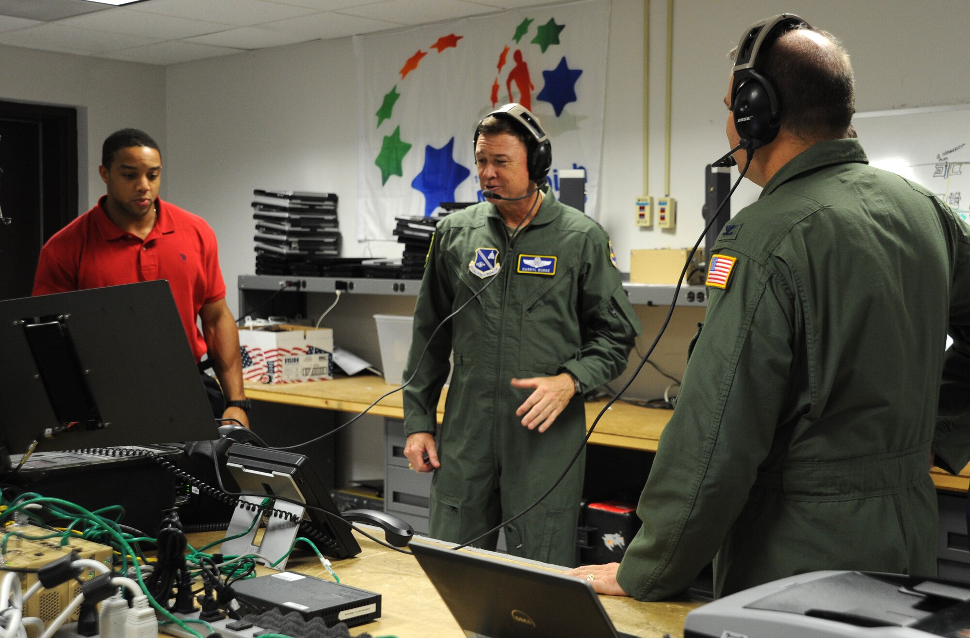 Staff Sgt. Glenn Lowry explains equipment used to provide secure phone communications to Air Force District of Washington Commander Maj. Gen. Darryl Burke and Vice Commander Col. Chris Patterson during the general’s visit to the 844th Communications Group at Joint Base Andrews, Maryland, Aug. 8, 2014. Lowry is a member of the Secretary of Defense Executive Travel Communications Team. (U.S. Air Force photo/Master Sgt. Tammie Moore)
