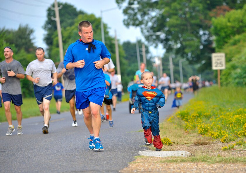 Staff Sgt. Bryan Johnson, 26th Operational Weather Squadron shift supervisor, finishes the Superhero 5K Fun Run with Superman on Barksdale Air Force Base, La., Aug. 8, 2014. Superman is also Johnson's son, who often participates in monthly 5K fun runs with his parents. (U.S. Air Force photo/Airman 1st Class Benjamin Raughton)