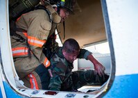 An Eglin Air Force Base firefighter extracts an injured victim to safety during a major accident response exercise Aug. 6 at Duke Field.  Emergency responders from the base and the city were called to a downed aircraft scenario featuring fire, wreckage and victims with multiple injuries. The responders had to work as a team and coordinate movements at the simulated crash site, put out fires and attend to the wounded victims. (U.S. Air Force photo/Tech. Sgt. Jasmin Taylor)