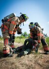 Eglin Air Force Base firefighters prepare to move a simulated victim during a major accident response exercise Aug. 6 at Duke Field.  Emergency responders from the base and the city were called to a downed aircraft scenario featuring fire, wreckage and victims with multiple injuries. The responders had to work as a team and coordinate movements at the simulated crash site, put out fires and attend to the wounded victims. (U.S. Air Force photo/Tech. Sgt. Jasmin Taylor)