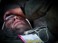 Master Sgt. Michael Sims, 5th Special Operations Squadron, simulates the pain from a head wound during a major accident response exercise Aug. 6 at Duke Field.  The simulated accident was a mid-air collision of a 33rd Fighter Wing joint strike fighter and a 919th Special Operations Wing C-145. Emergency responders from the base and the city were called to a downed aircraft scenario featuring fire, wreckage and victims with multiple injuries. The responders had to work as a team and coordinate movements at the simulated crash site, put out fires and attend to the wounded victims. (U.S. Air Force photo/Tech. Sgt. Jasmin Taylor)
