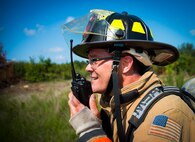 An Eglin Air Force Base firefighter communicates with firemen responding to the damage during a major accident response exercise Aug. 6 at Duke Field.  Emergency responders from the base and the city were called to a downed aircraft scenario featuring fire, wreckage and victims with multiple injuries. The responders had to work as a team and coordinate movements at the simulated crash site, put out fires and attend to the wounded victims. (U.S. Air Force photo/Tech. Sgt. Jasmin Taylor)