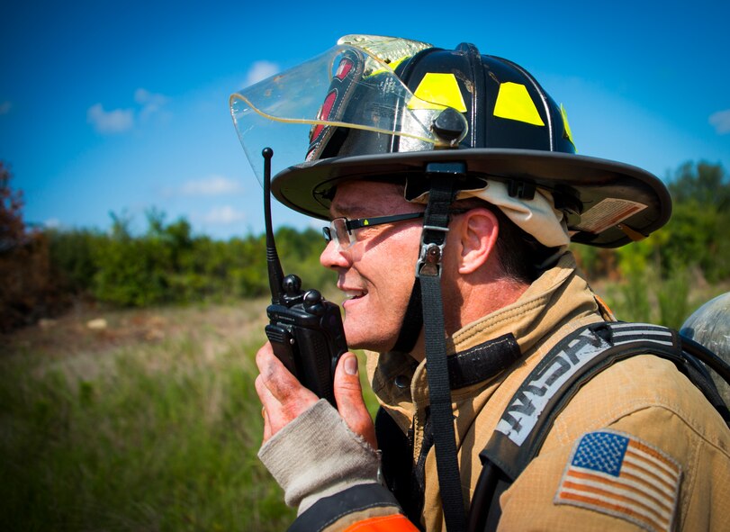 An Eglin Air Force Base firefighter communicates with firemen responding to the damage during a major accident response exercise Aug. 6 at Duke Field.  Emergency responders from the base and the city were called to a downed aircraft scenario featuring fire, wreckage and victims with multiple injuries. The responders had to work as a team and coordinate movements at the simulated crash site, put out fires and attend to the wounded victims. (U.S. Air Force photo/Tech. Sgt. Jasmin Taylor)
