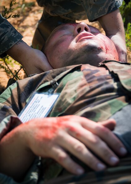 Senior Airman Christianson Parker, 919 Special Operations Support Squadron, receives simulated medical treatment during a major accident response exercise Aug. 6 at Duke Field.  Emergency responders from the base and the city were called to a downed aircraft scenario featuring fire, wreckage and victims with multiple injuries. The responders had to work as a team and coordinate movements at the simulated crash site, put out fires and attend to the wounded victims. (U.S. Air Force photo/Tech. Sgt. Jasmin Taylor)