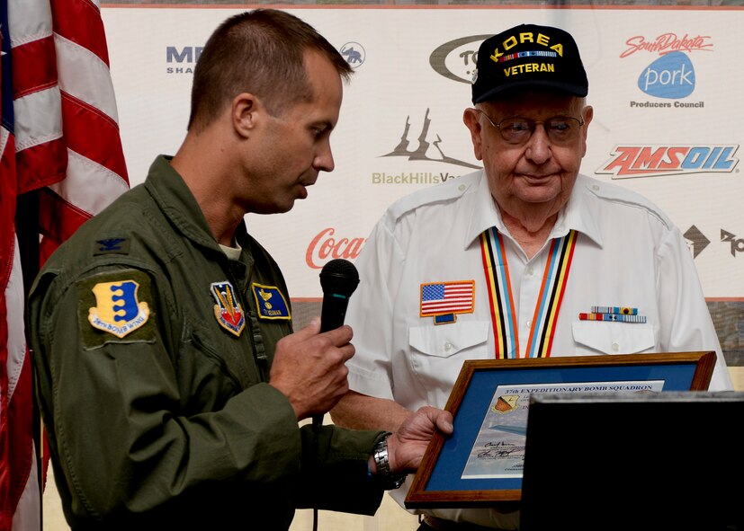 Col. Ty Neuman, 28th Bomb Wing vice commander, presents DeWayne Hayes, a Korean War veteran, with a U.S. flag flown over Afghanistan in support of Operation Enduring Freedom during the 2014 Dakota Thunder Motorcycle Run at Sturgis, S.D., Aug. 5, 2014. Hayes joined the U.S. Air Force in October of 1950 when he was stationed at McChord Air Force Base, Wash., before getting transferred to Ellsworth, then known as Rapid City Air Force Base. In 1953, Hayes arrived at Kimpo Air Force Base in Korea, where he served as a target controller with the 67th Tactical Reconnaissance Group Intelligence. (U.S. Air Force photo by Senior Airman Anania Tekurio/Released)