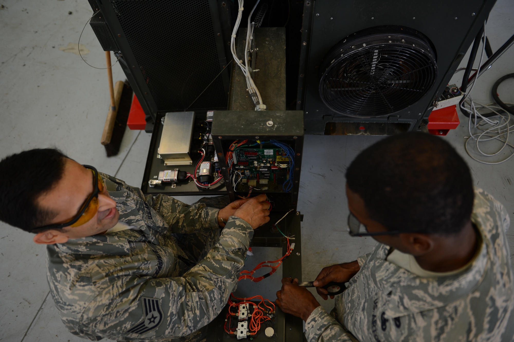 Staff Sgt. Rod Castillo and Tech. Sgt. Dedric Brown, 624th CES HVAC/R craftsmen, from Joint Base Pearl Harbor, Hawaii, inspect the parts of a field-deployable, environmental-control unit on Ramstein Air Base, Germany, Aug. 6, 2014. This seven-day training was to ensure CES Airmen from around the Air Force were up to speed on their HVAC abilities. (U.S. Air Force photo/Airman 1st Class Michael Stuart)