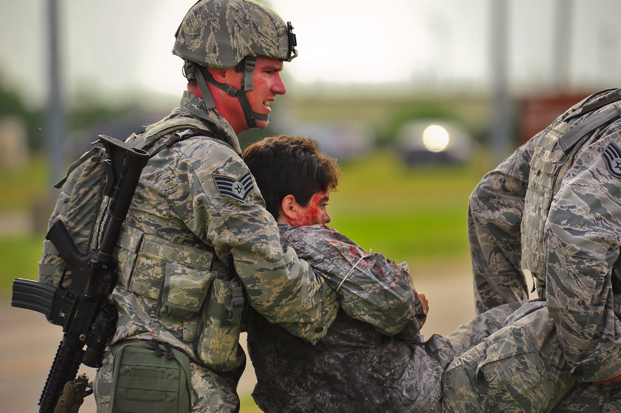 Staff Sgts. Colin Vessels and William Leyk, 5th Security Forces Squadron military response force members, 2-man carry a simulated wounded victim during an exercise on Minot Air Force Base, N.D., Aug. 5, 2014. The purpose of the exercise was to evaluate and validate the integration and response of emergency management, security forces, fire department, bioenvironmental and medical response members in a simulated radiological terrorist incident on Minot AFB. (U.S. Air Force photo/Senior Airman Brittany Y. Bateman)