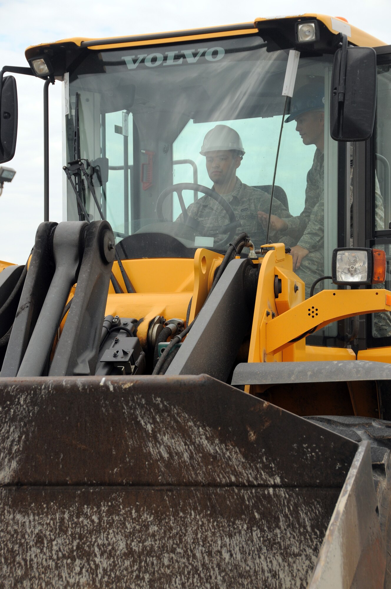 WRIGHT-PATTERSON AIR FORCE BASE, Ohio – Airman Mitchell Ruiz receives instruction from Senior Airman Joel Olsen during front end loader training on July 12, 2014.  Ruiz and Olsen are assigned to the 445th Civil Engineer Squadron heavy equipment operator and pavements section.  (U.S. Air Force photo/ Tech. Sgt. Anthony Springer)