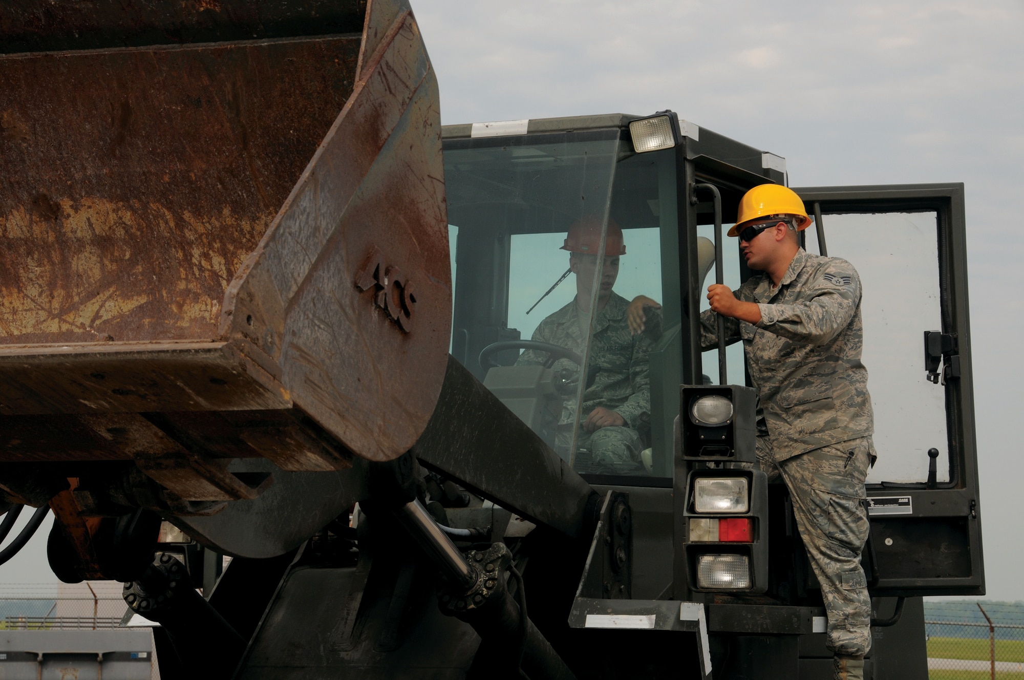 WRIGHT-PATTERSON AIR FORCE BASE, Ohio – 445th Civil Engineering  Squadron’s  Senior Airman Michael Johnson, pavements and construction apprentice, gives instructions to fellow CE reservist  Senior Airman Alexander Mosholder, electrical services helper, before operating a bulldozer during the July 12 unit training assembly.  (U.S. Air Force photo/ Tech. Sgt. Anthony Springer)