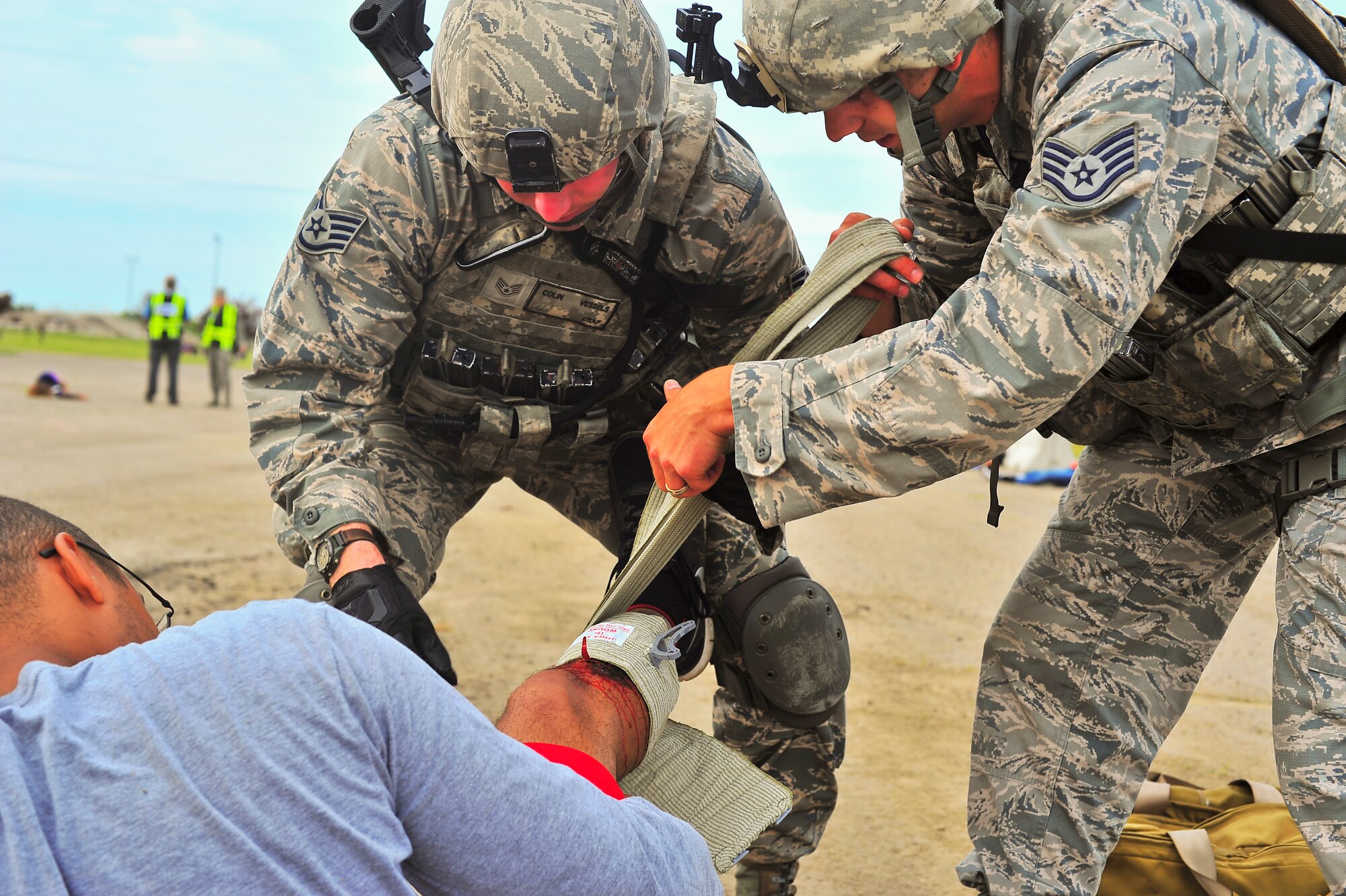 Staff Sgts. Colin Vessels and William Leyk, 5th Security Forces Squadron members, provide medical care to simulated wounded victims during an exercise on Minot Air Force Base, N.D., Aug. 5, 2014. The purpose of the exercise was to evaluate and validate the integration and response of emergency management, security forces, fire department, bioenvironmental and medical response members in a simulated radiological terrorist incident on Minot AFB. (U.S. Air Force photo/Senior Airman Brittany Y. Bateman)