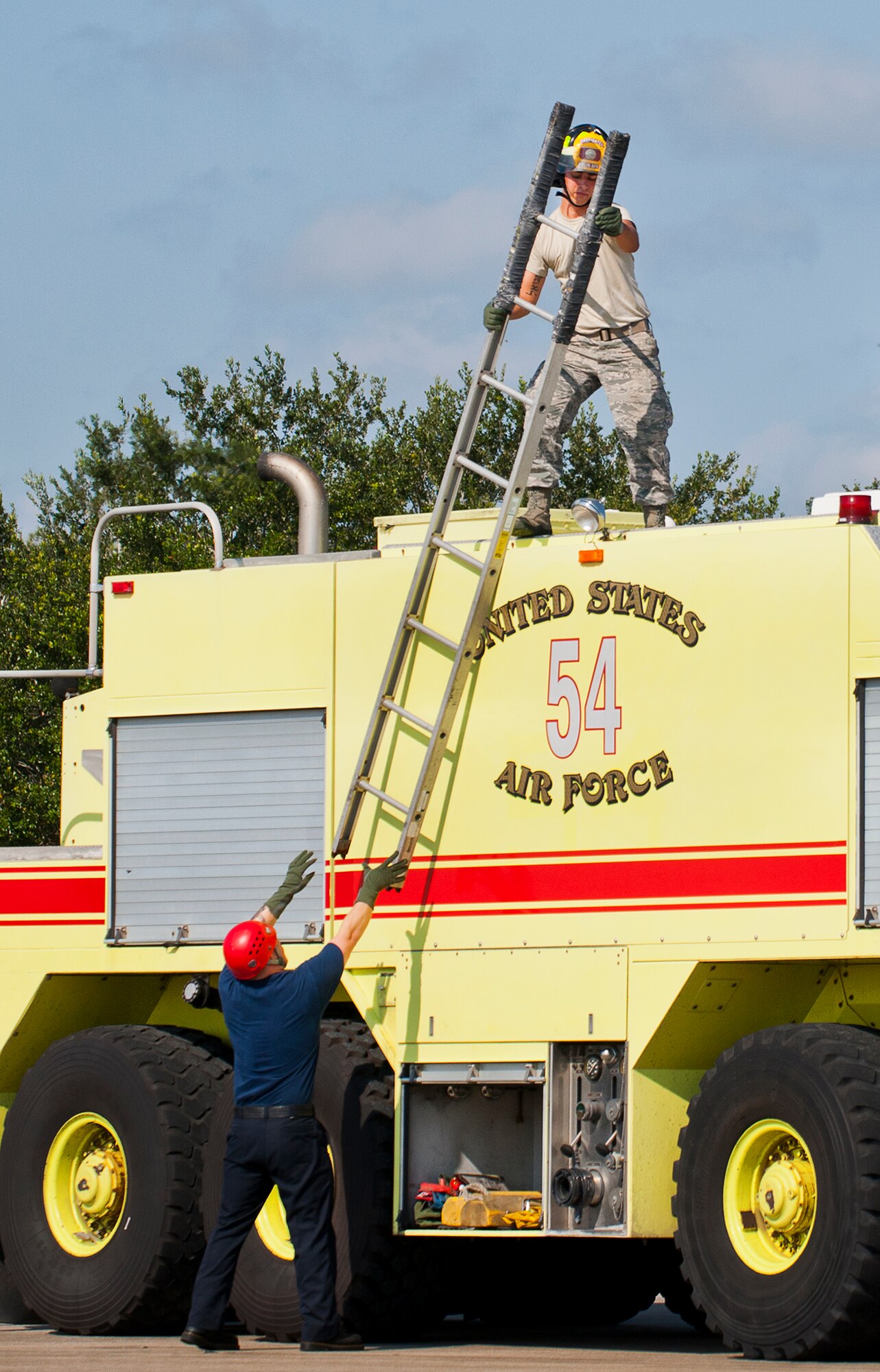 Eglin Air Force Base firefighters remove a ladder to be used to access an F-35A Lightning II during a joint-base major accident response exercise between Eglin Air Force Base and Duke Field, Fla., Aug. 6.  The simulated accident was a mid-air collision of a 33rd Fighter Wing joint strike fighter and a 919th Special Operations Wing C-145.  First responders had to react to both accidents simultaneously, secure the scene, put out fires and help the wounded.  (U.S. Air Force photo/Tech. Sgt. Samuel King Jr.)