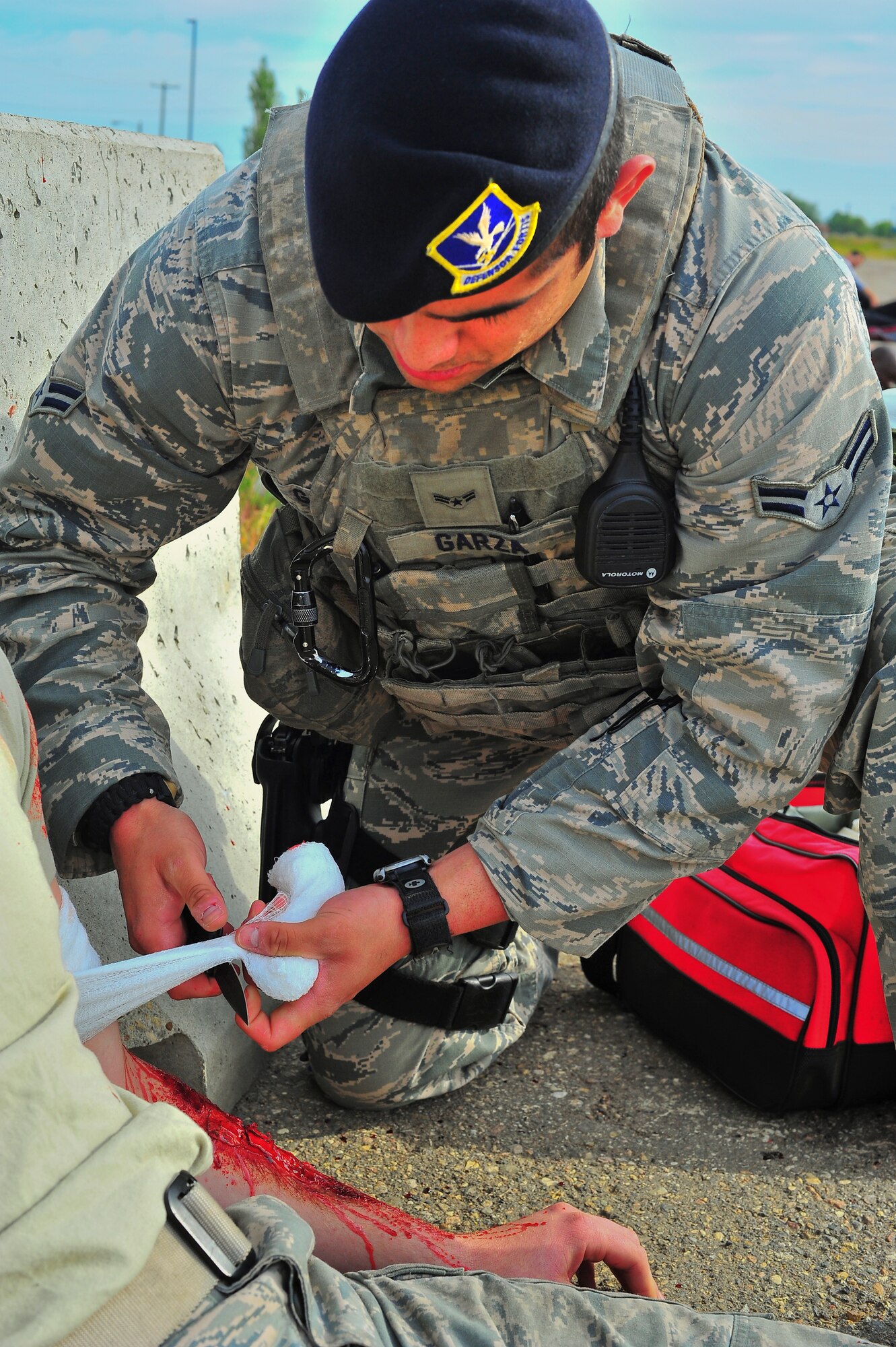 Airman 1st Class Emil Garza, 5th Security Forces Squadron member, tends to simulated wounded victims during an exercise on Minot Air Force Base, N.D., Aug. 5, 2014. The exercise focused on the base’s ability to respond, survive and operate in a chemical, biological, radiological or nuclear contaminated environment. (U.S. Air Force photo/Senior Airman Brittany Y. Bateman)