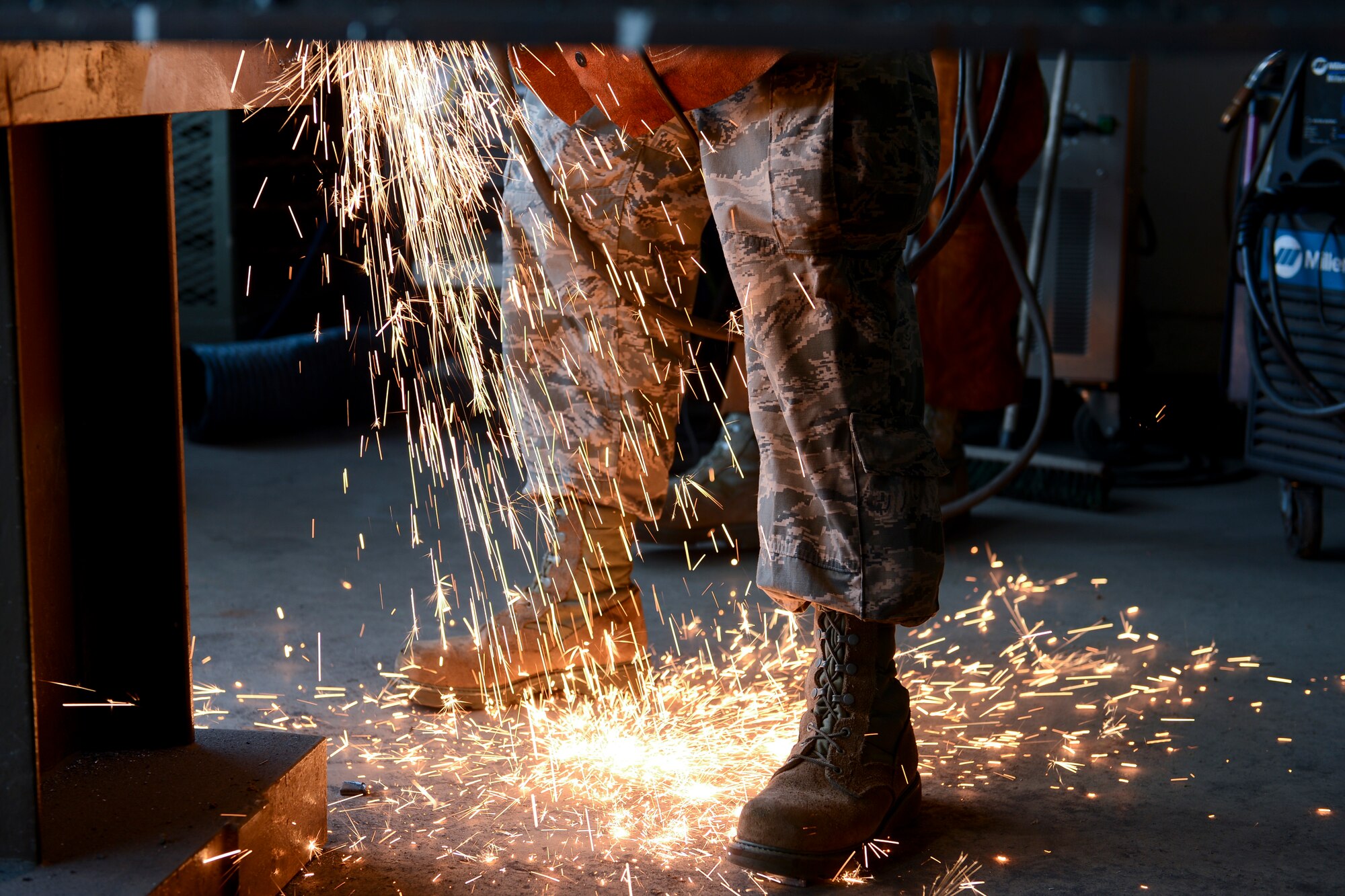 Airman First Class Brandon Slagle, 786th Civil Engineer Squadron structural journeyman, welds together two pieces of metal as sparks cover his boots on Ramstein Air Base, Germany, Aug. 6, 2014. Along with welding, the 786th CES also performs other functions such as blacksmithing and  electrical power production, to name a few.  The 786th CES builds and maintains structures and utilities on and off Ramstein. (U.S. Air Force photo/Airman 1st Class Michael Stuart)