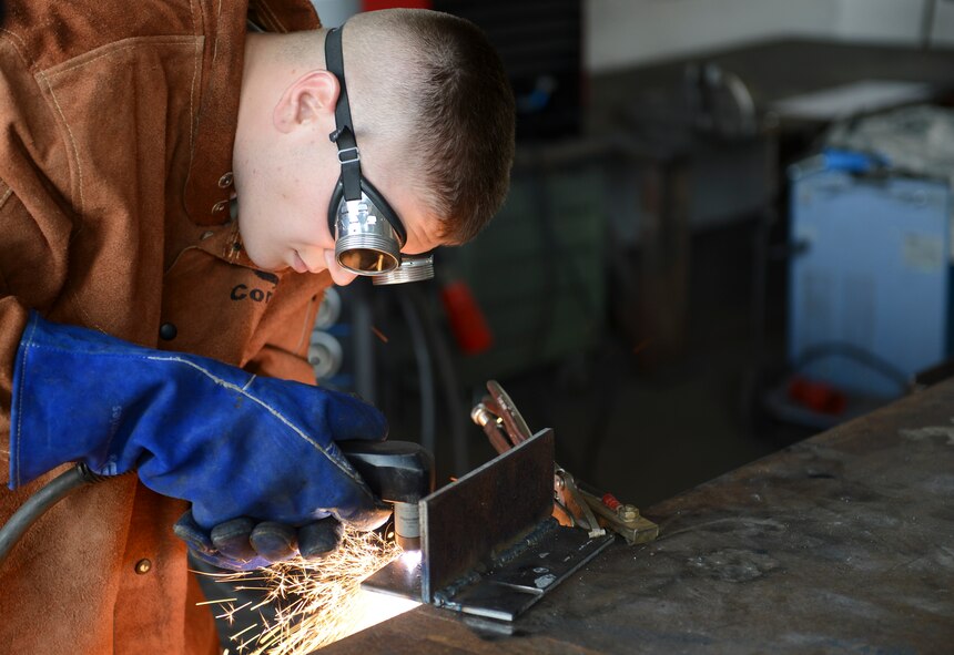 Airman First Class Brandon Slagle, 786th Civil Engineer Squadron structural journeyman, welds metal plates together on Ramstein Air Base, Germany, Aug. 6, 2014. Welding is the joining of two or more metals to repair or build structures by melting two materials together and forming a solid joint. The 786th CES builds and maintains structures and utilities on and off Ramstein. (U.S. Air Force photo/Airman 1st Class Michael Stuart)