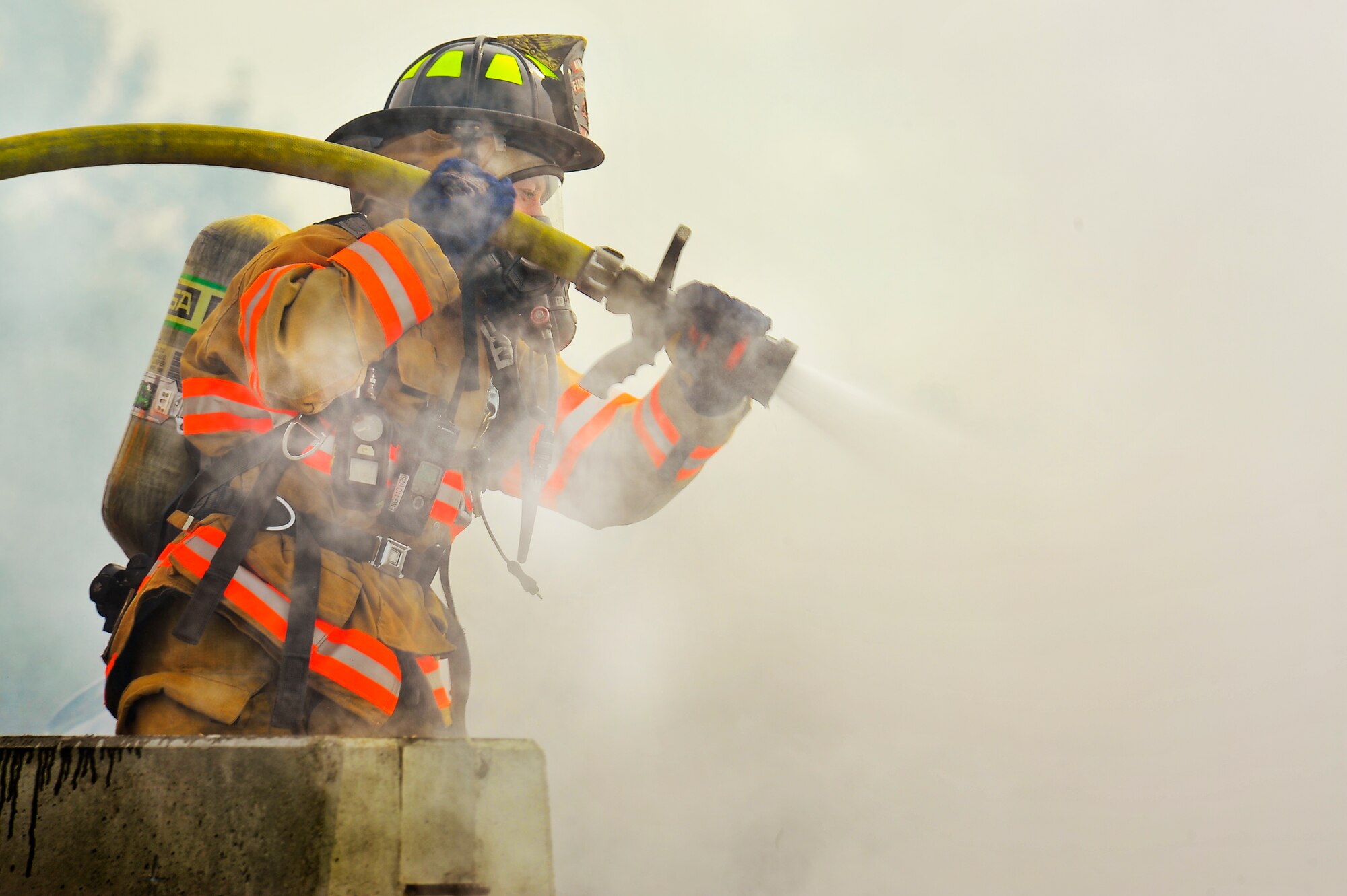 Fire fighters from the 5th Civil Engineer Squadron put out a fire during an exercise on Minot Air Force Base, N.D., Aug. 5, 2014. The exercise focused on the ability to respond, survive and operate in a chemical, biological, radiological or nuclear contaminated environment. (U.S. Air Force photo/Senior Airman Brittany Y. Bateman)