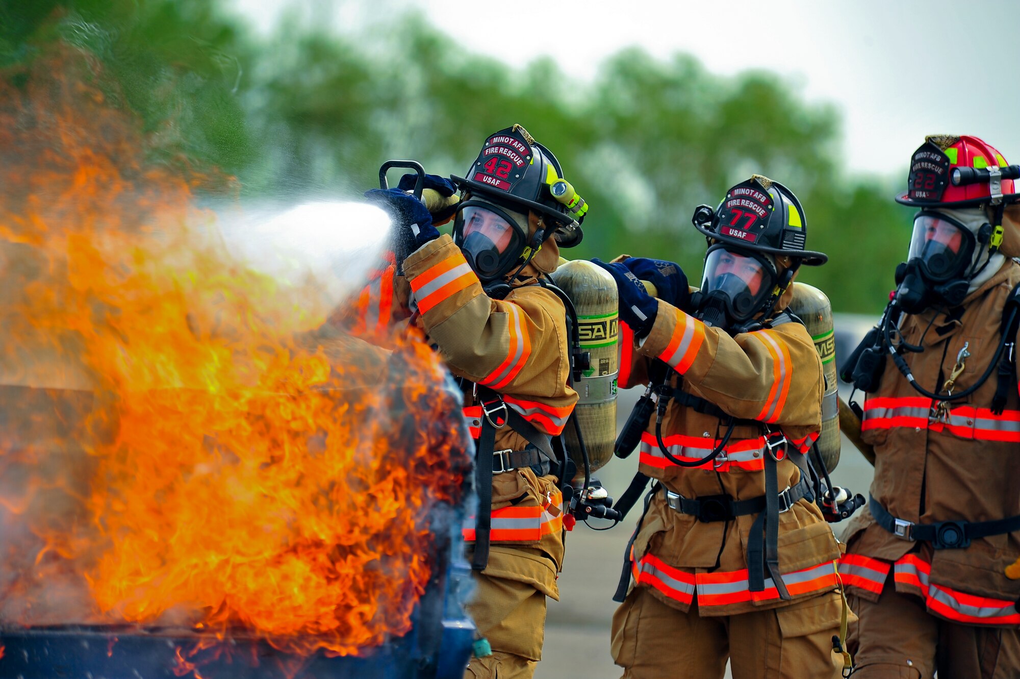 Fire fighters from the 5th Civil Engineer Squadron put out a fire during an exercise on Minot Air Force Base, N.D., Aug. 5, 2014. The exercise focused on the ability to respond, survive and operate in a chemical, biological, radiological or nuclear contaminated environment. (U.S. Air Force photo/Senior Airman Brittany Y. Bateman)