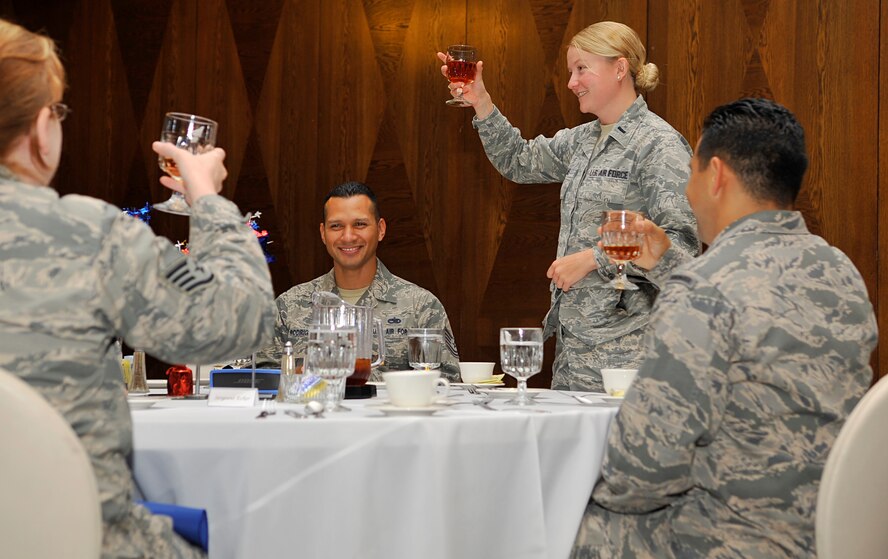 First Lt. Amara Adams, 39th Air Base Wing chief of protocol at Incirlik Air Base, Turkey, demonstrates how to formally give a toast during the Protocol Fundamental Course simulated retirement luncheon Aug. 1, 2014, at Ramstein Air Base, Germany. The course attendees learned to manage many aspects of protocol to include ceremonies, distinguished visitors and fine dining etiquette. (U.S Air Force photo/Airman Larissa Greatwood)
