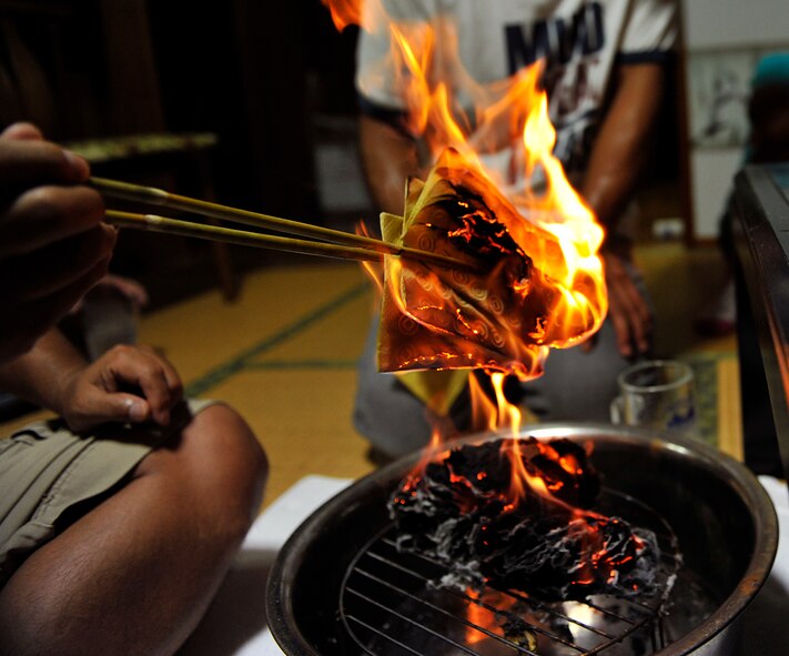 Sousei Yamakawa, owner of the house, burns uchikabi, which is the paper spirit money during the last day of Obon at Yomitan village, Japan, Aug. 10, 2014. In Okinawa, Obon runs throughout July 13-15 on the old lunar calendar, which means this year it falls throughout Aug. 8-10. The three days of Obon are called Unke, known as the welcoming day; Nakabi, which is dedicated to visiting relative's homes; and Ukui, which is dedicated to sending the ancestral spirits back to the other world. (U.S. Air Force photo by Naoto Anazawa)