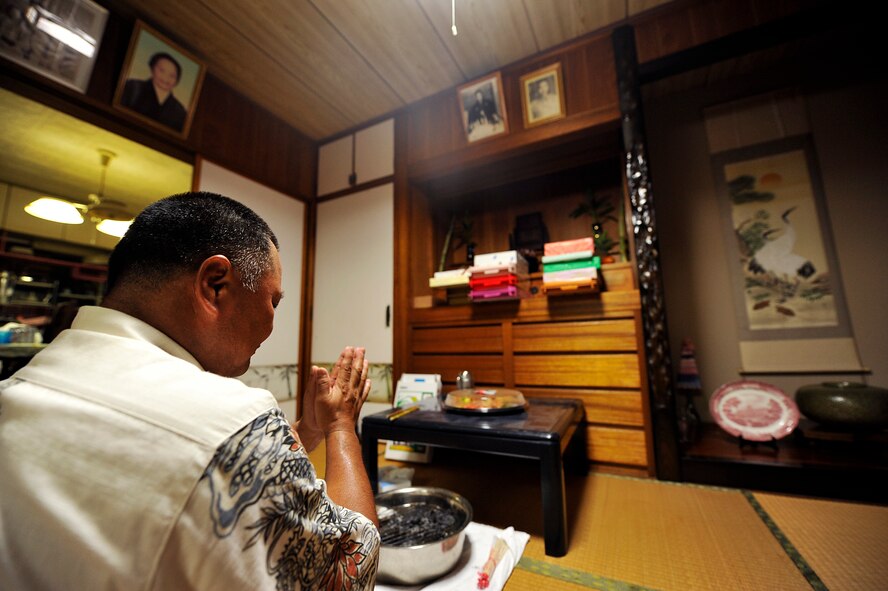 Sousei Yamakawa, owner of the house, prays for his family's and relative's safety and happiness in front of Butsudan before sending ancestral spirits back to the other world at Yomitan village, Okinawa, Japan, Aug. 10, 2014. Okinawans invite their ancestral spirits to visit the family's Butsudan during this traditional period. (U.S. Air Force photo by Naoto Anazawa) 